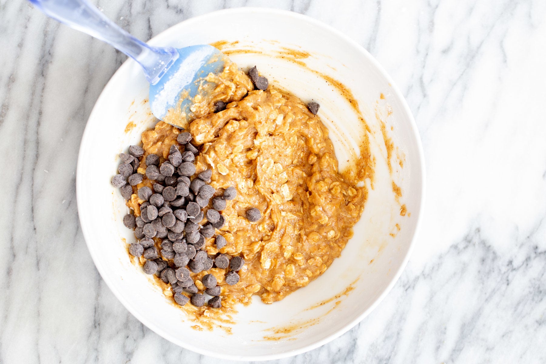 chocolate chips being added to vegan oatmeal bar base