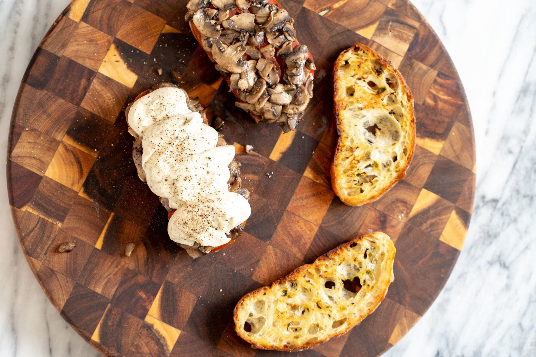 vegan cheese melts bread sliced being topped with sauteed mushrooms and vegan mozarella cheese