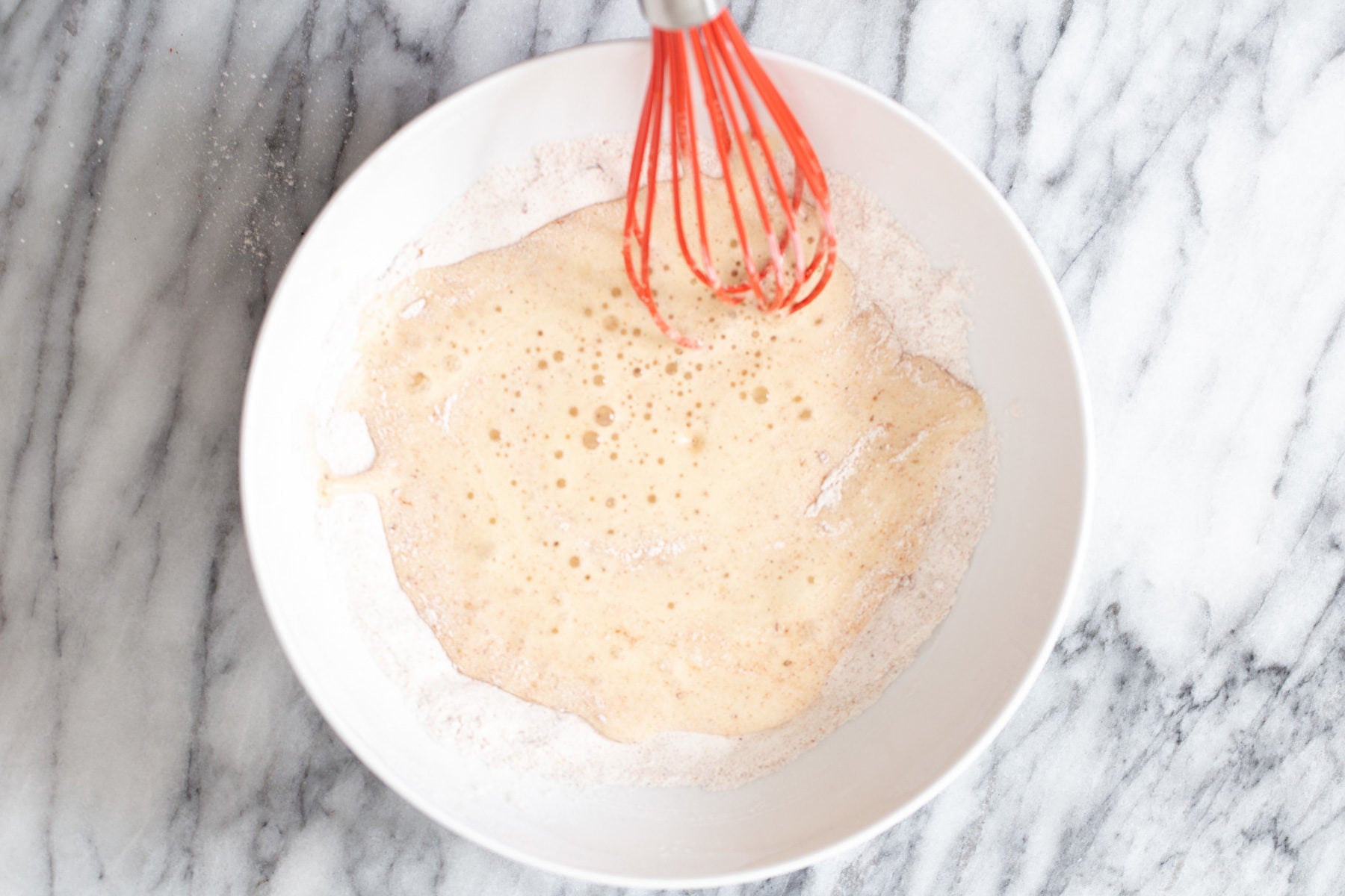 cauliflower wings vegan beer batter being mixed in a small white bowl