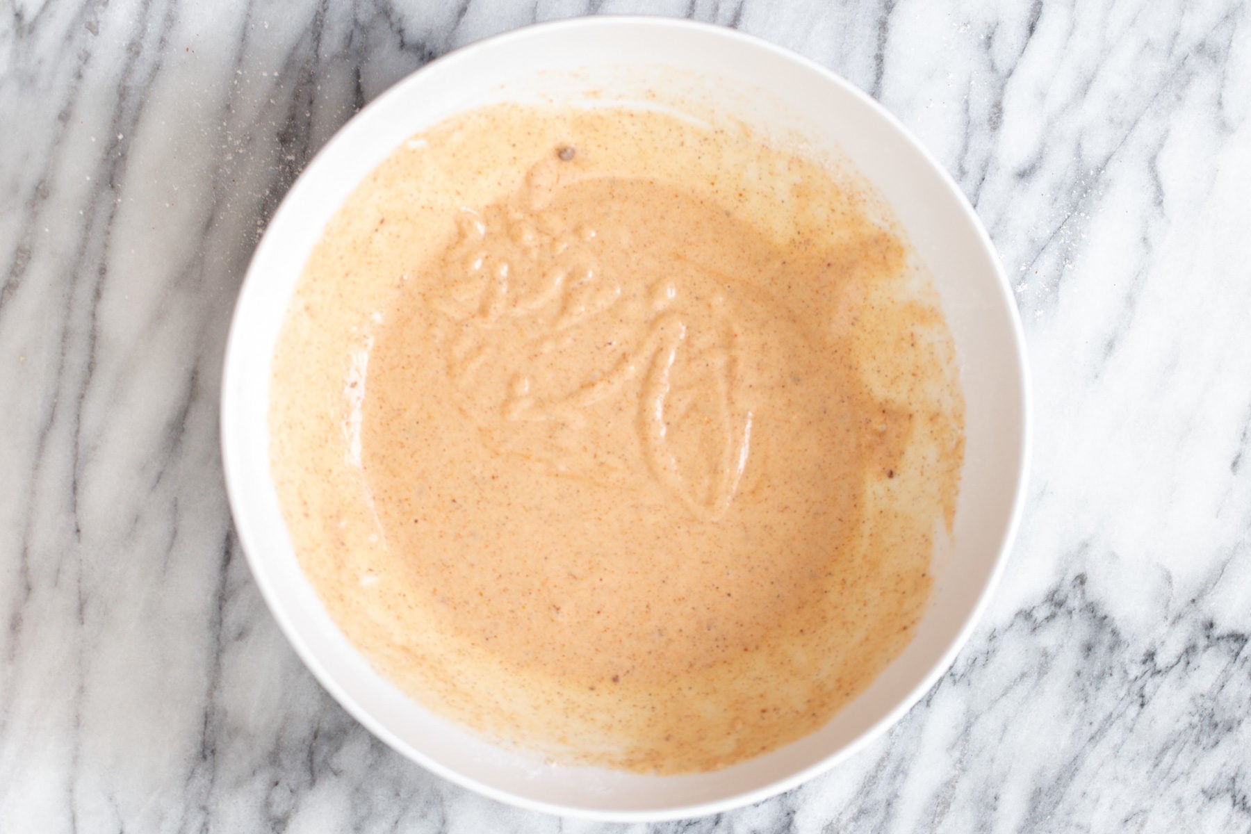 cauliflower wings beer batter for vegan cauliflower wings in a small white bowl