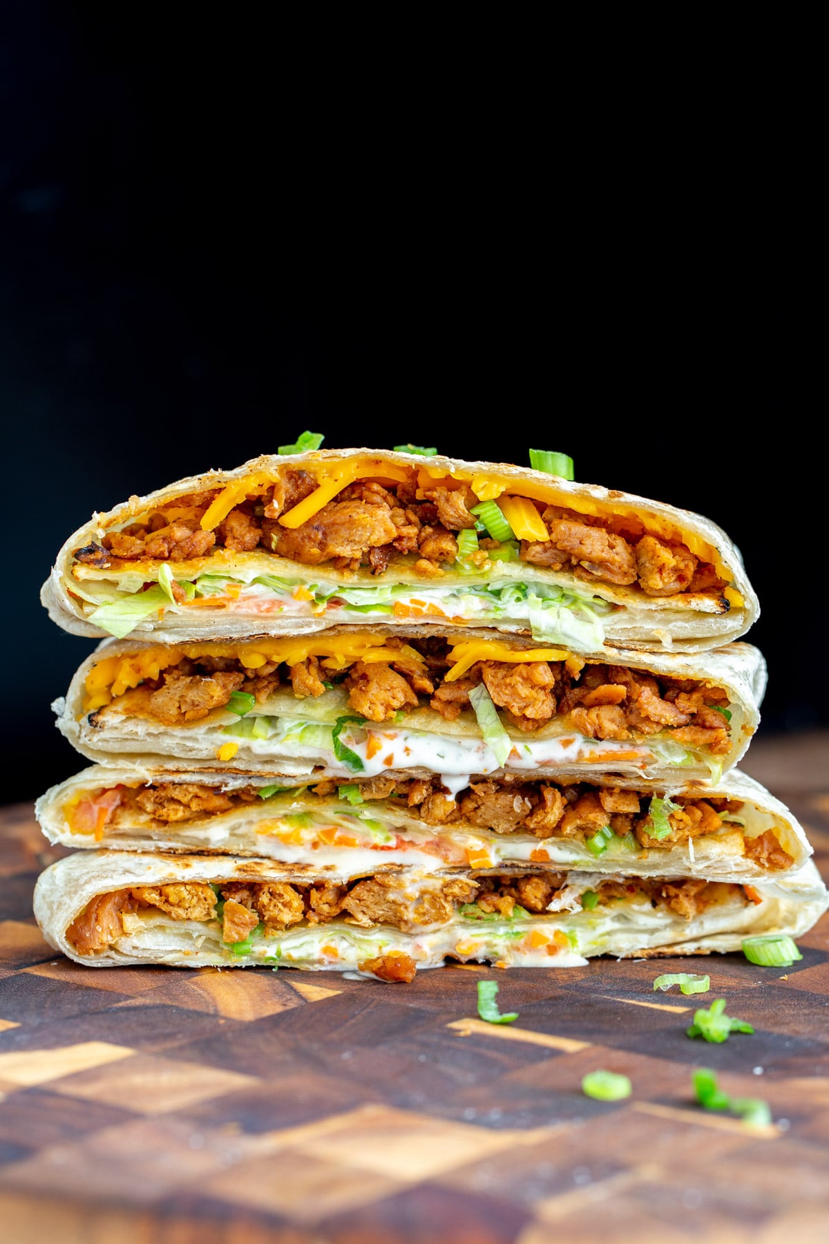 vegan crunchwrap vegan Korean bbq crunchwrap stacked on a wooden board