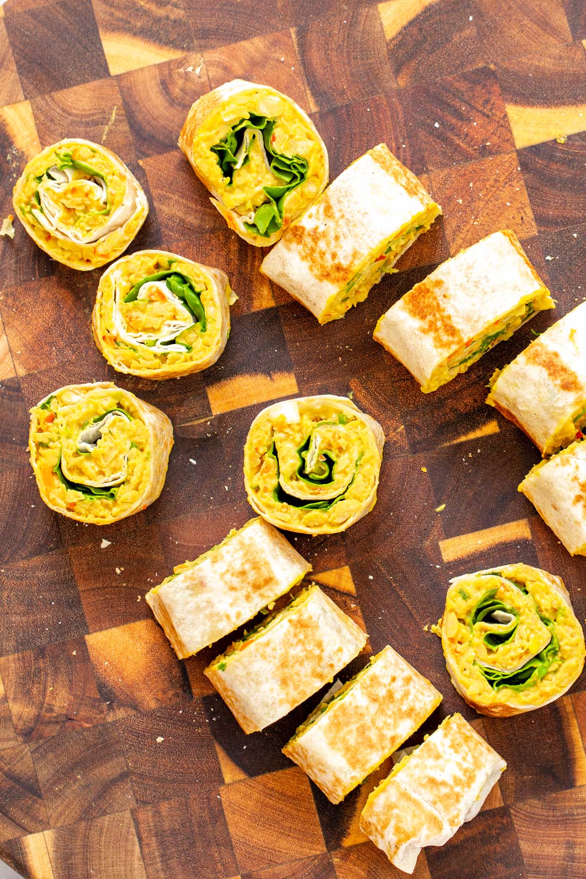 vegan chickpea scramble wraps being sliced into pinwheels 