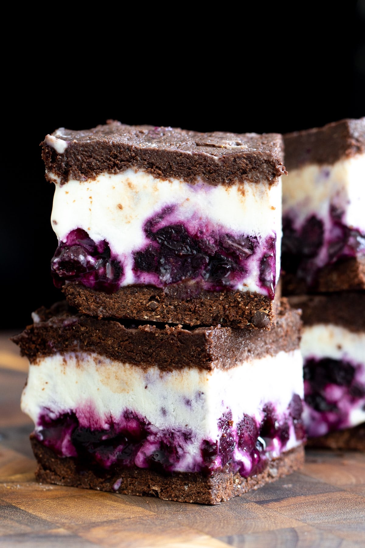 close-up of two stacked vegan chocolate vanilla ice cream sandwiches with blueberry swirl 