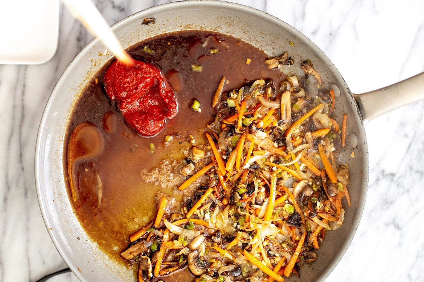 gochujang noodles sauce ingredients for gochujang sauce being added to sauteed veggies in a saucepan