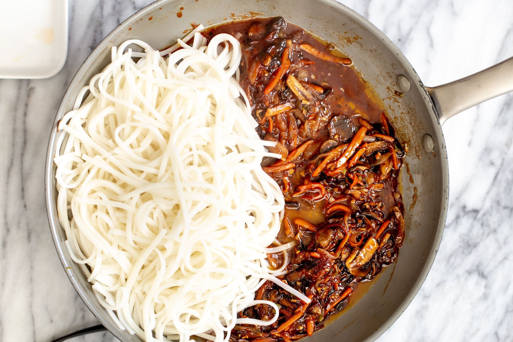 gochujang noodles cooked rice noodles and veggies with Korean stir-fry sauce in a saucepan