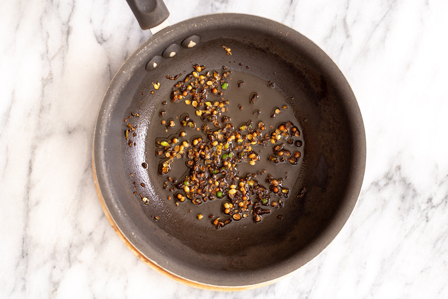 whole spices simmering in hot oil to make temering mixture for curry