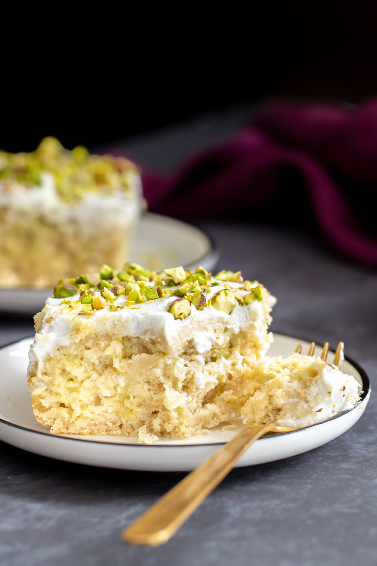 vegan tres leches a half eaten piece of vegan ras malai tres leches cake with a golden fork on the side