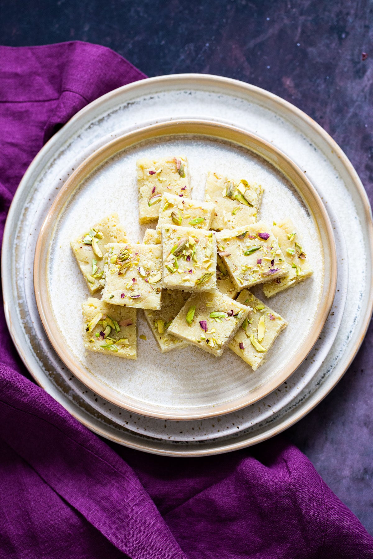 a plate with almond burfi topped with chopped pistachios and almonds