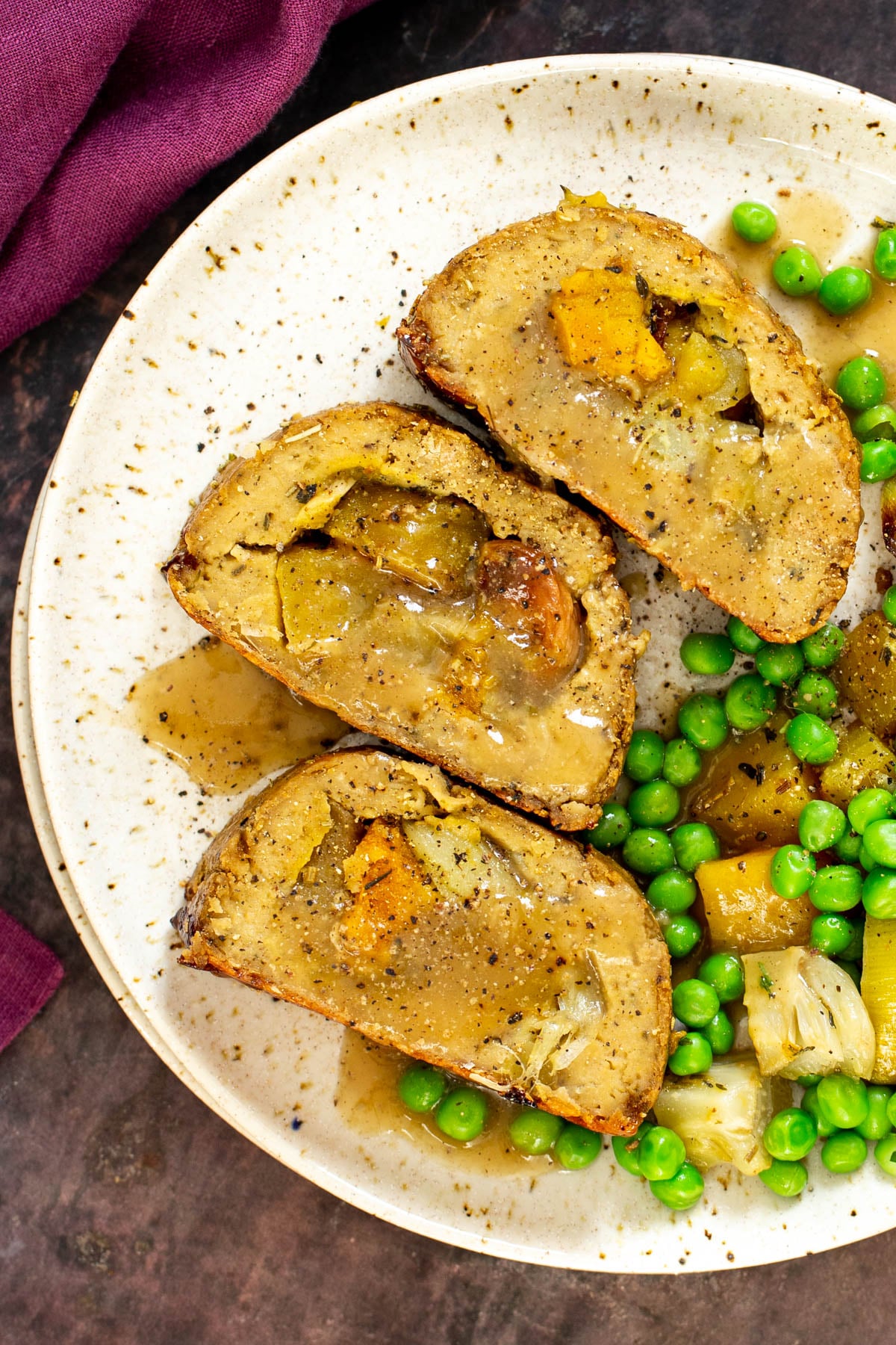 three slices of vegan glutenfree holiday roast with a side of veggies