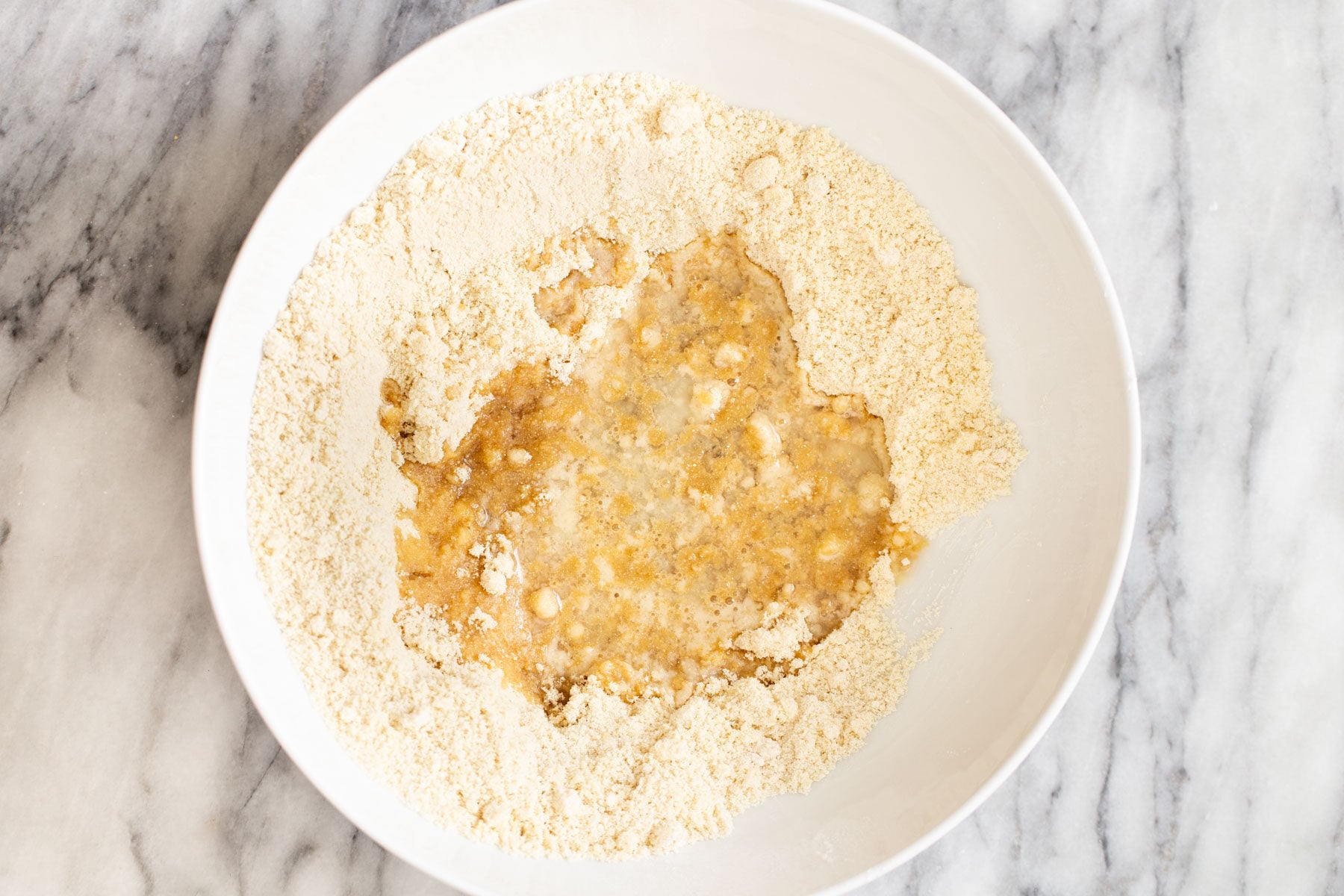 vegan pecan pie bars coconut oil being added to dry mix to make base for vegan pecan pie bars