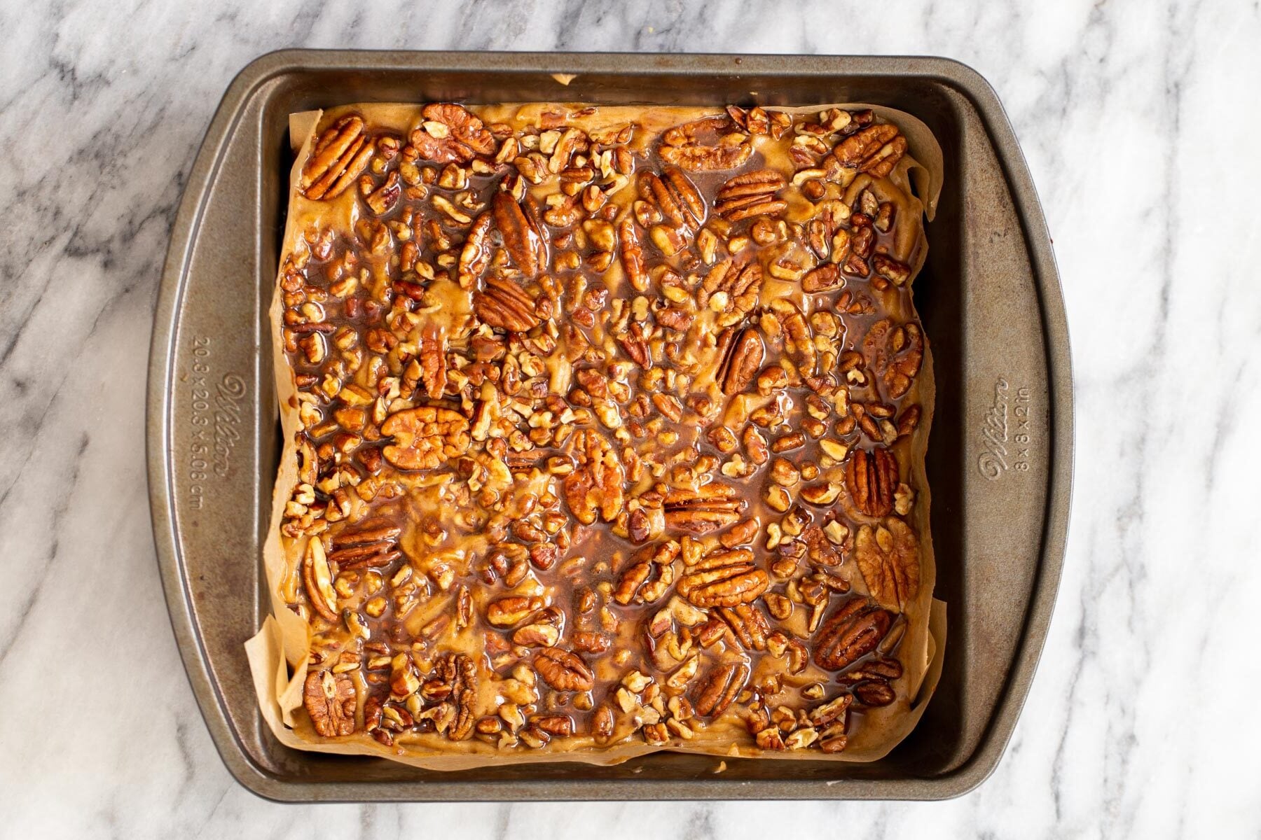 vegan pecan pie bars shortcrust pastry topped with pecans and maple syrup