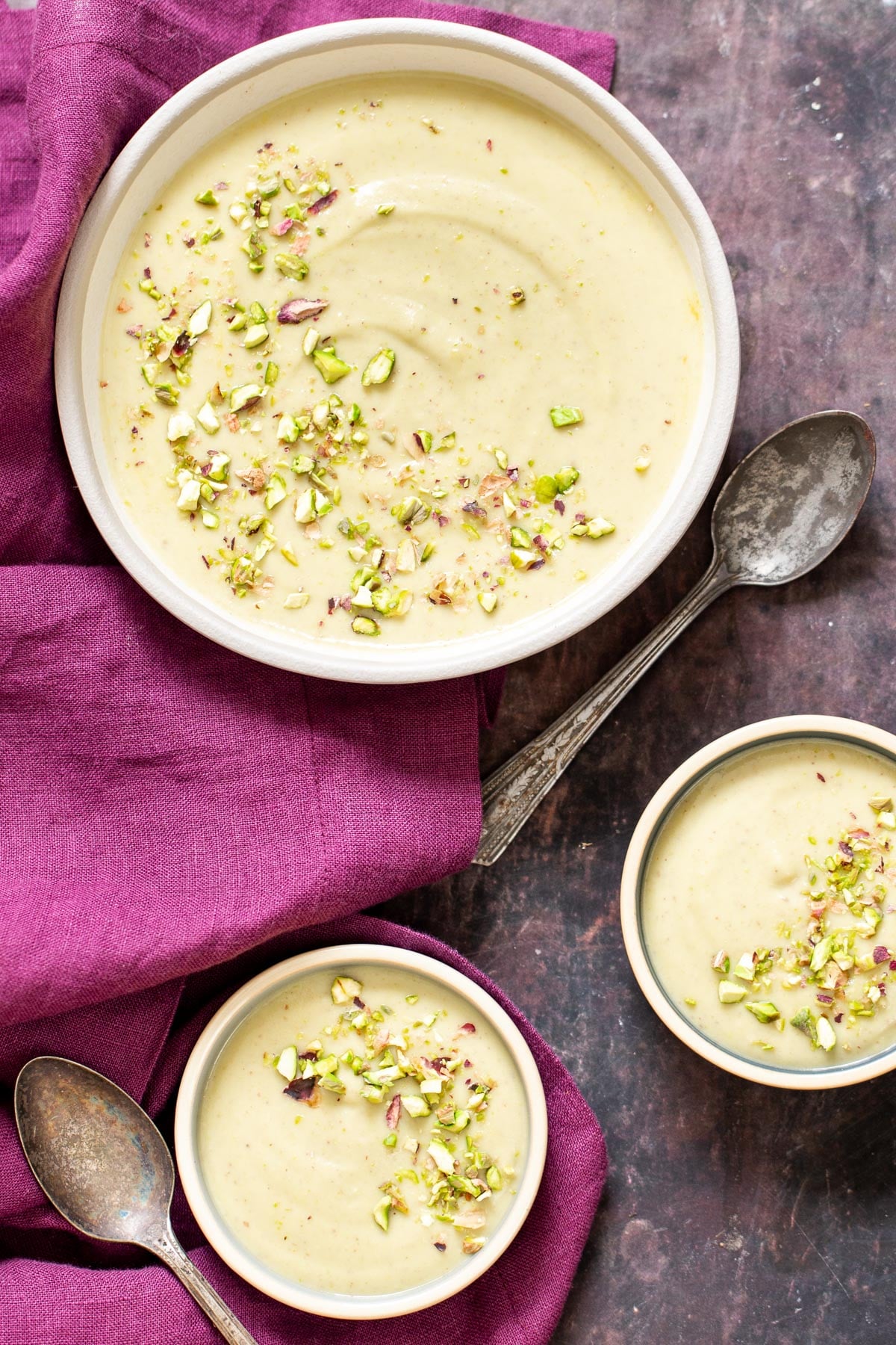 three servings of Indian Pudding Rabri topped with chopped pistachios