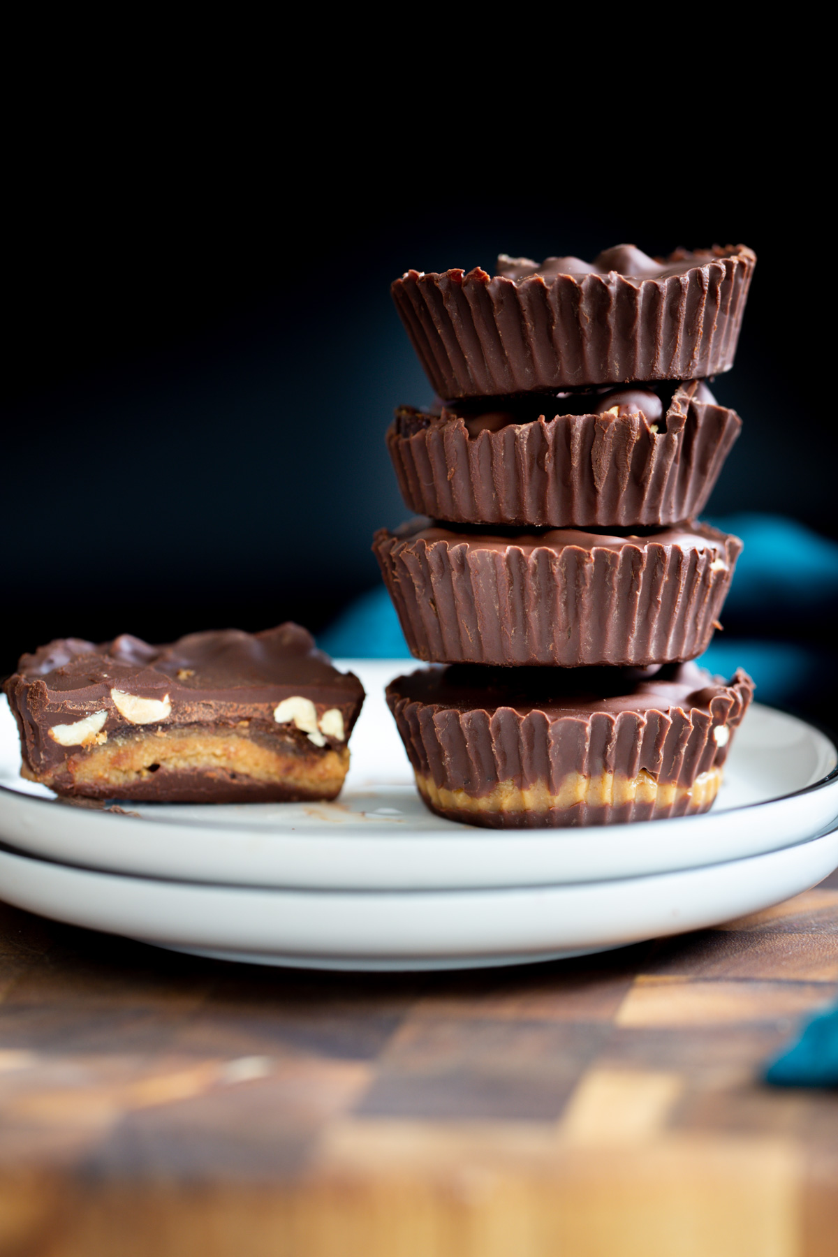 vegan snickers cups vegan peanut butter snickers cups with dates against a black background