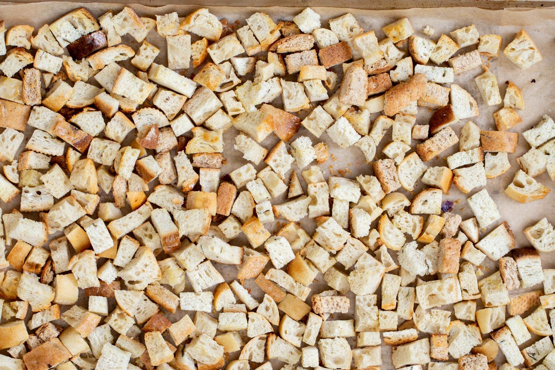 vegan stuffing bread cubes toasting on a baking sheet