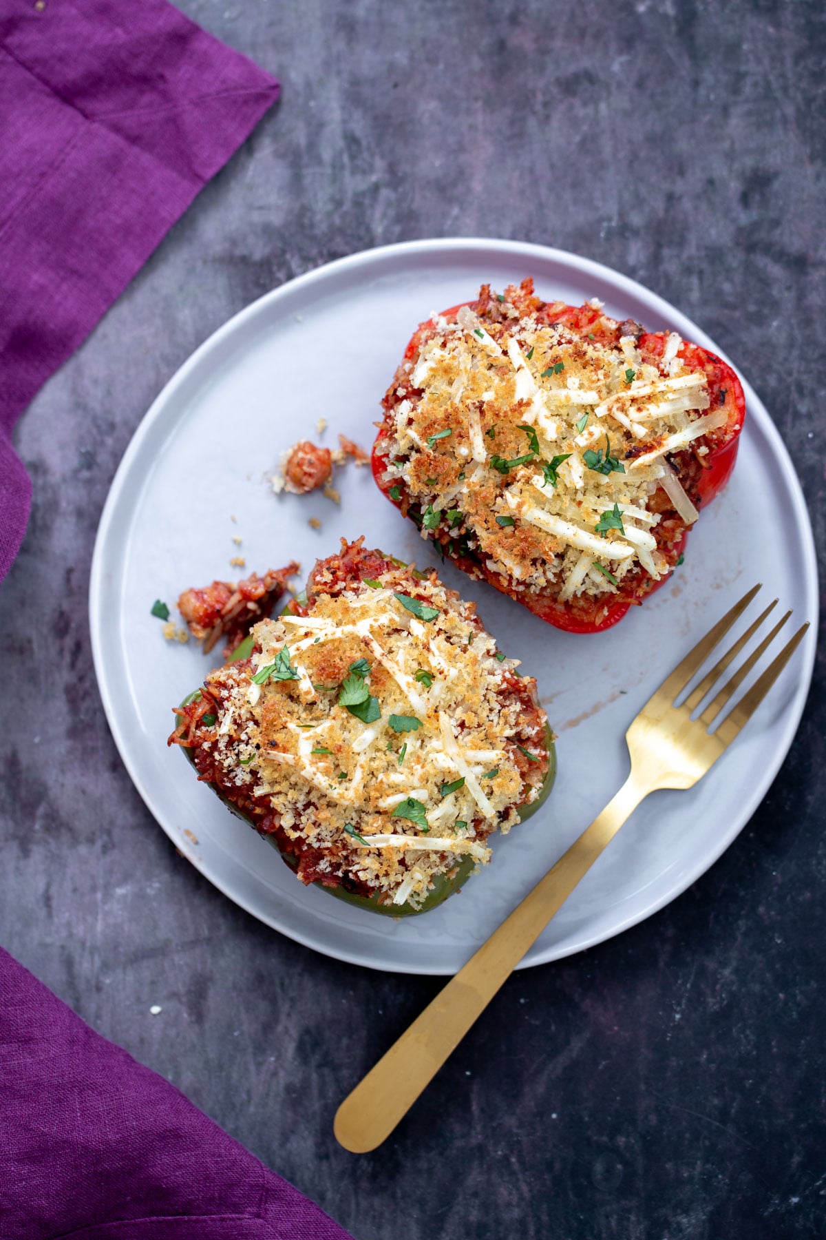 vegan stuffed bell peppers topped with crispy breadcumbs and vegan cheese