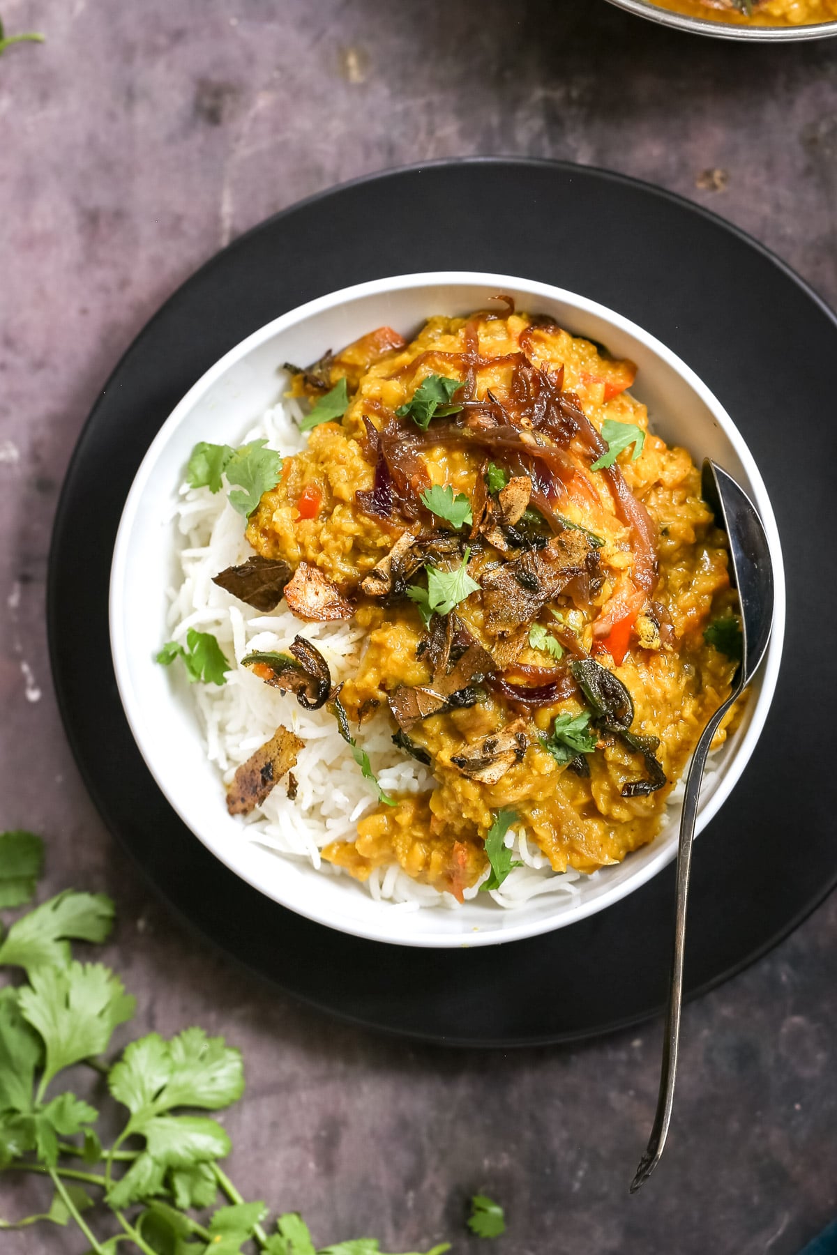 masoor dal tadka served over rice sprinkled with cilantro
