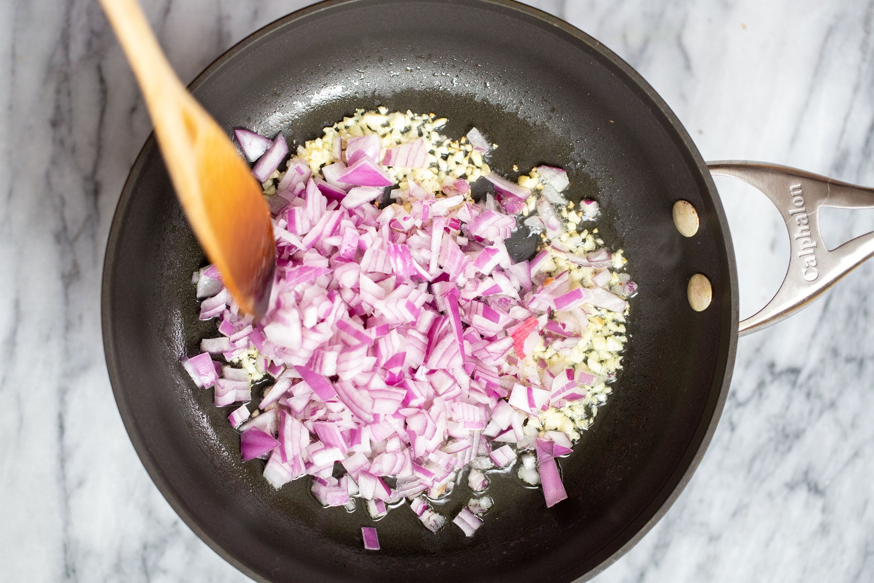 minced garlic and chopped red onions in a pan