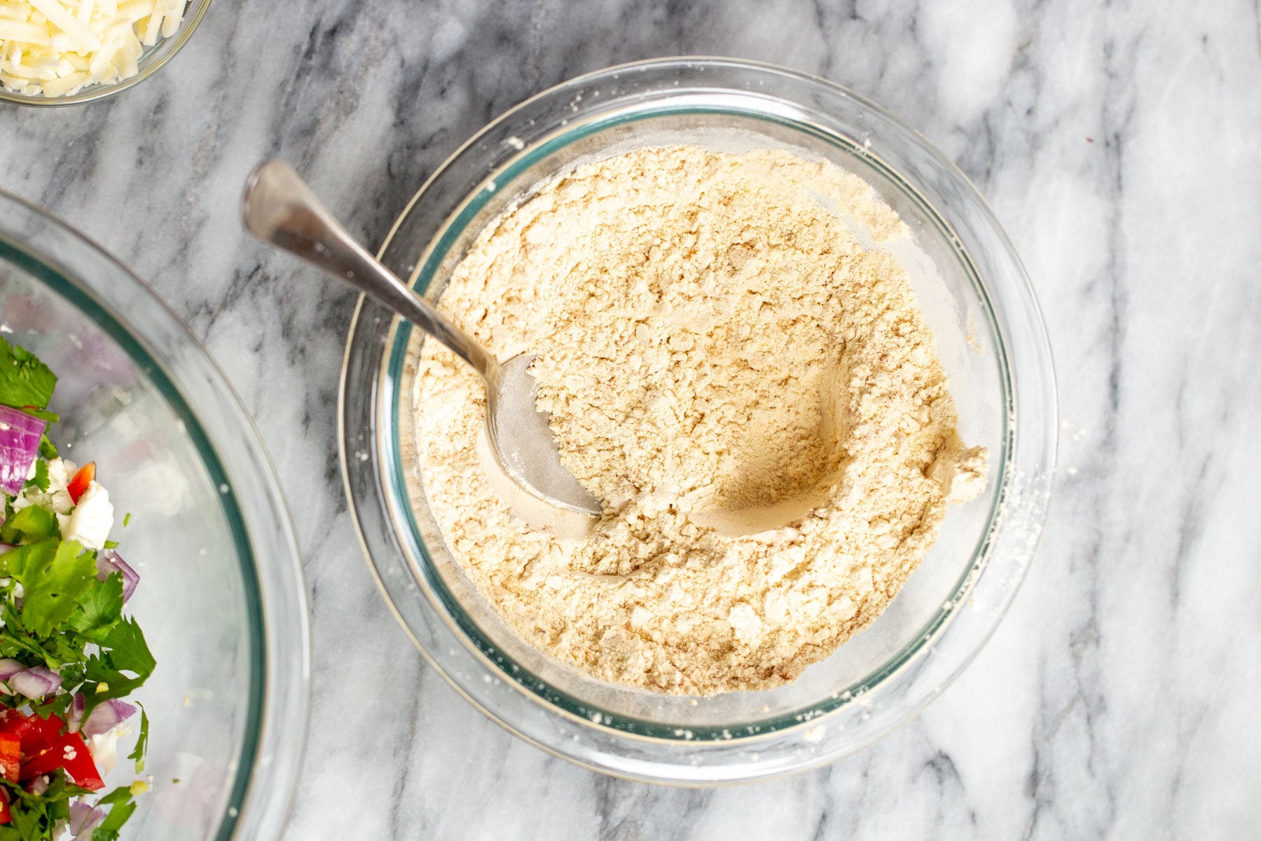 dry ingredients for vegan breakfast sandwich being combined in a glass bowl