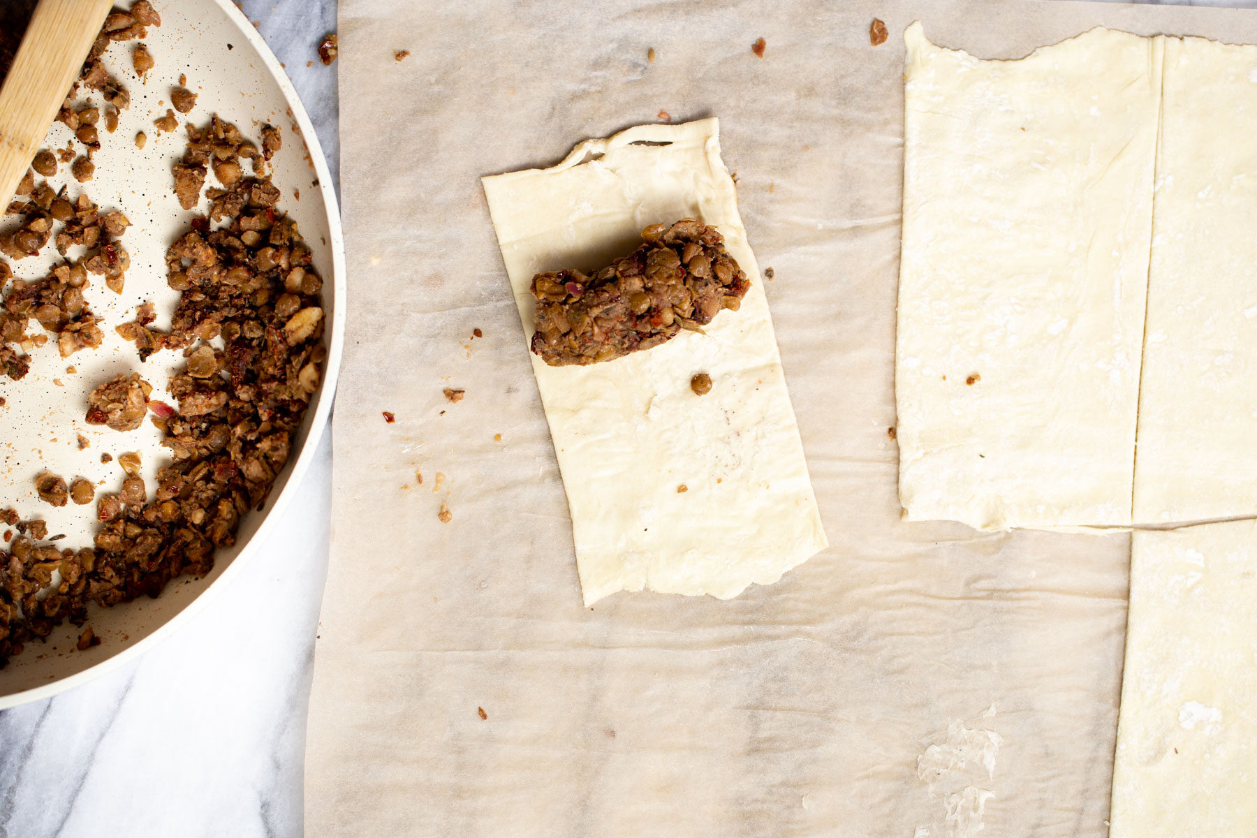 vegan sausage rolls lentils sausage stuffing being scooped on puff pastry