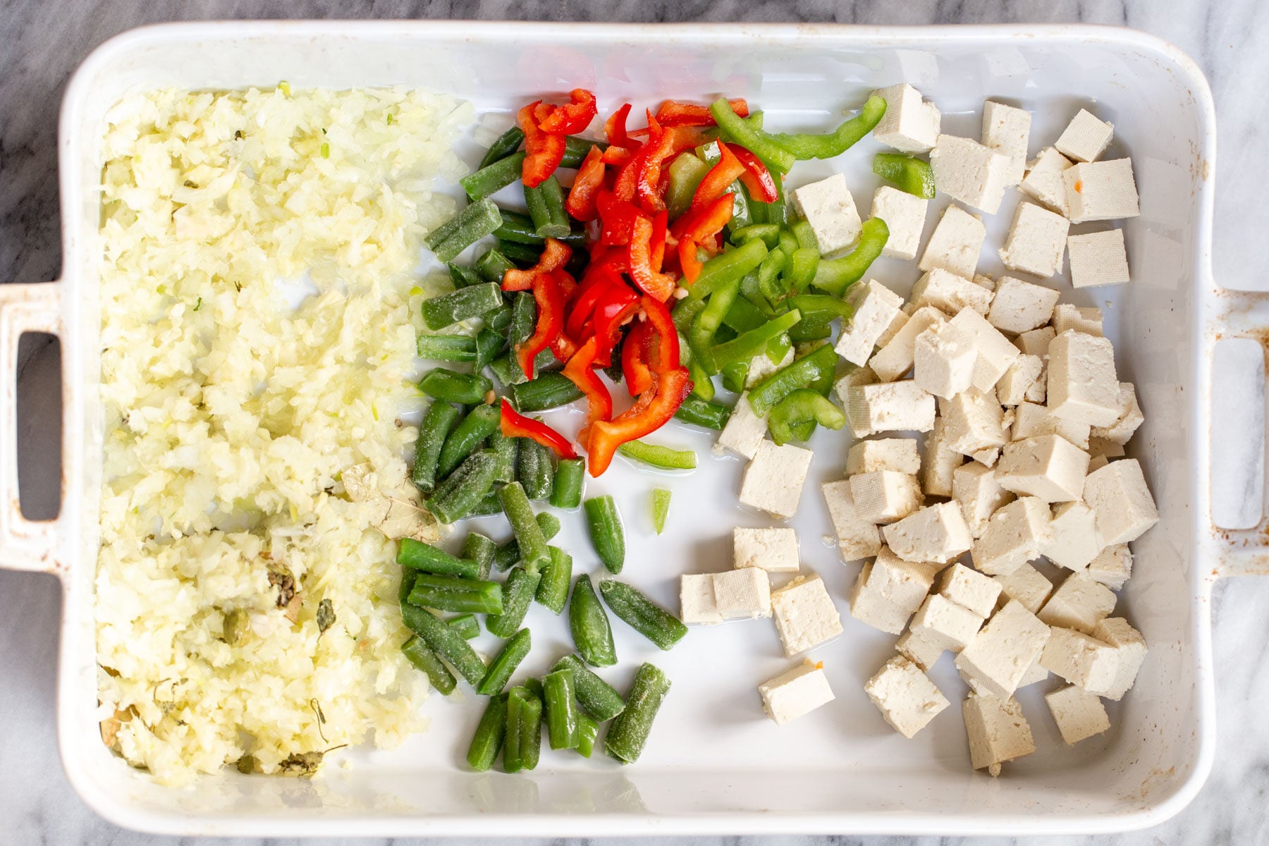 Navratan Korma a casserole dish with ginger, garlic and chopped veg as well as tofu in a white casserole dish