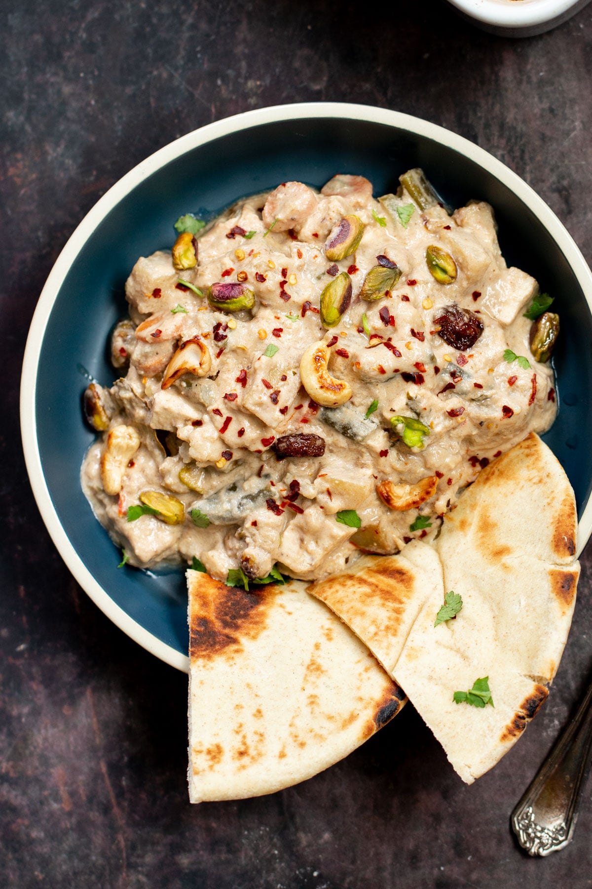 Navratan Korma a bowl of Baked Vegan Navratan Korma topped with chopped nuts and red chili flakes
