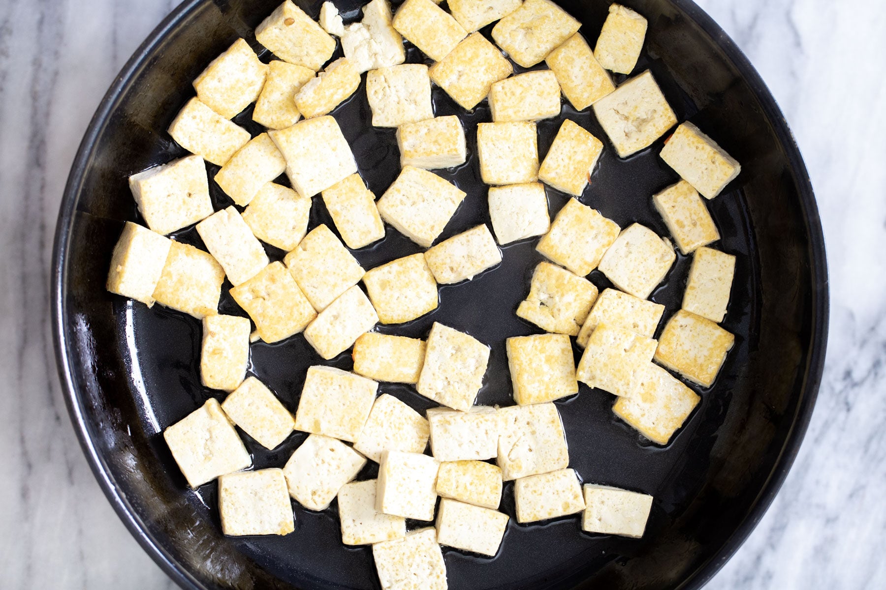 seared golden tofu in a frying pan