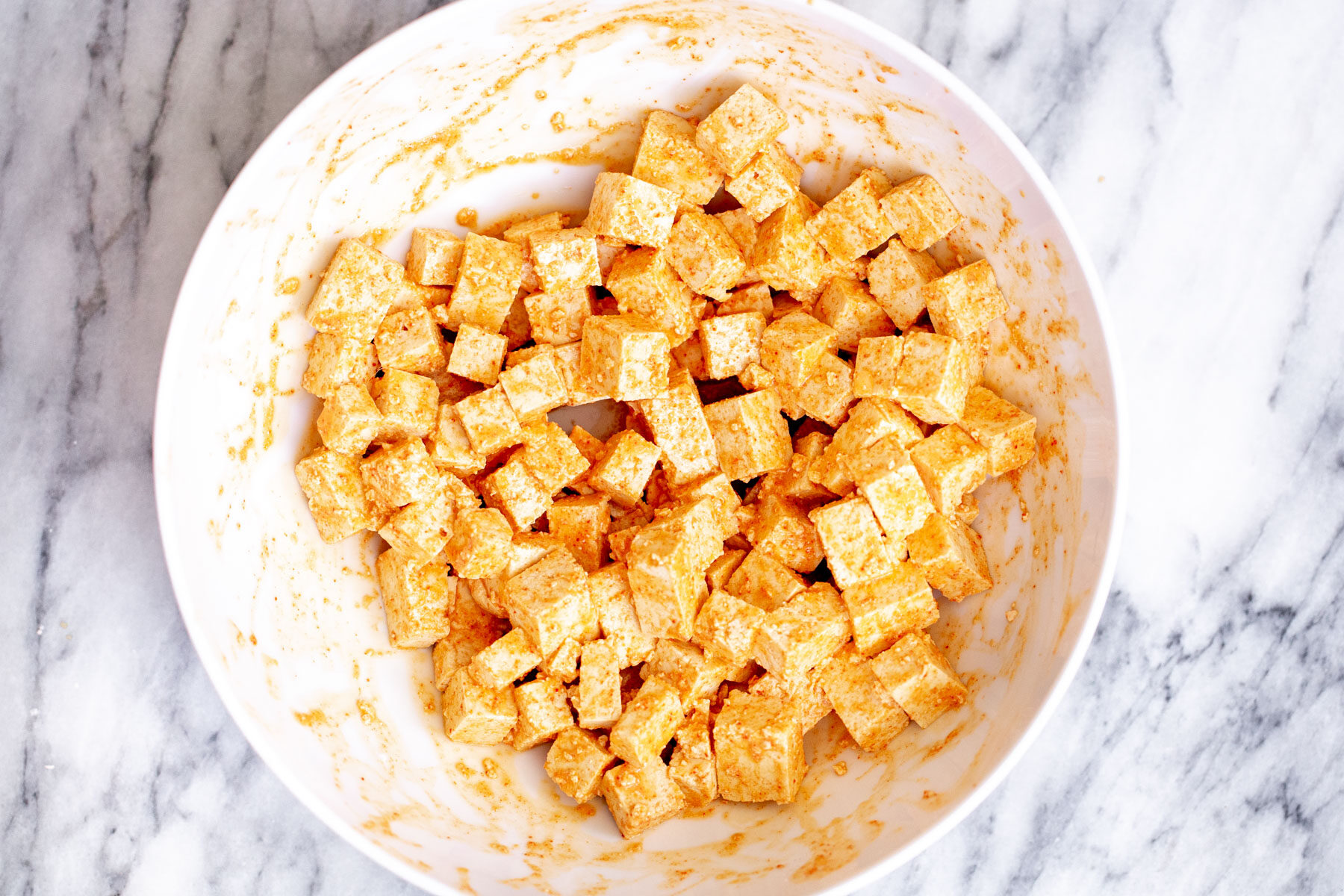 tofu cubes with spice mix in a white plate