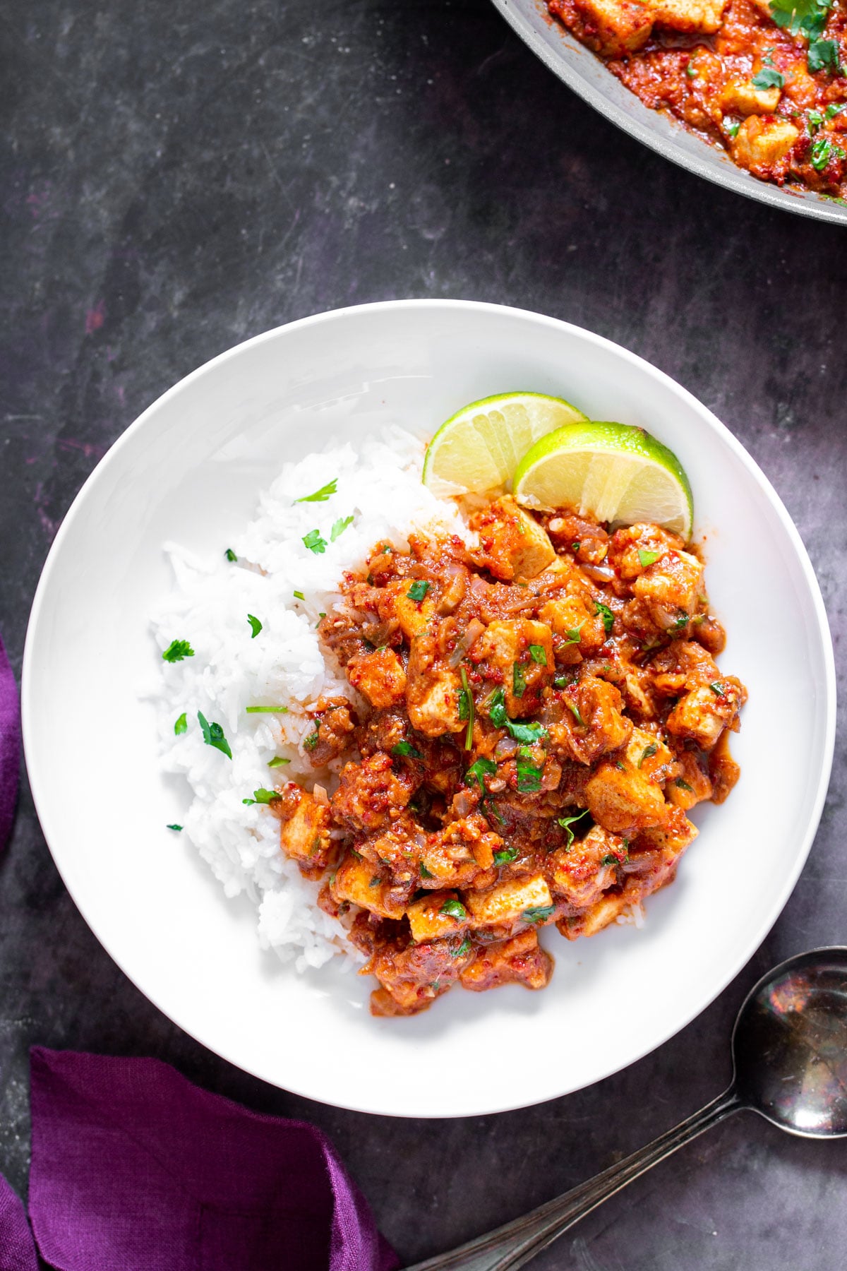 tofu vindaloo tofu vindaloo curry served with rice on a white plate with lime slices on the side