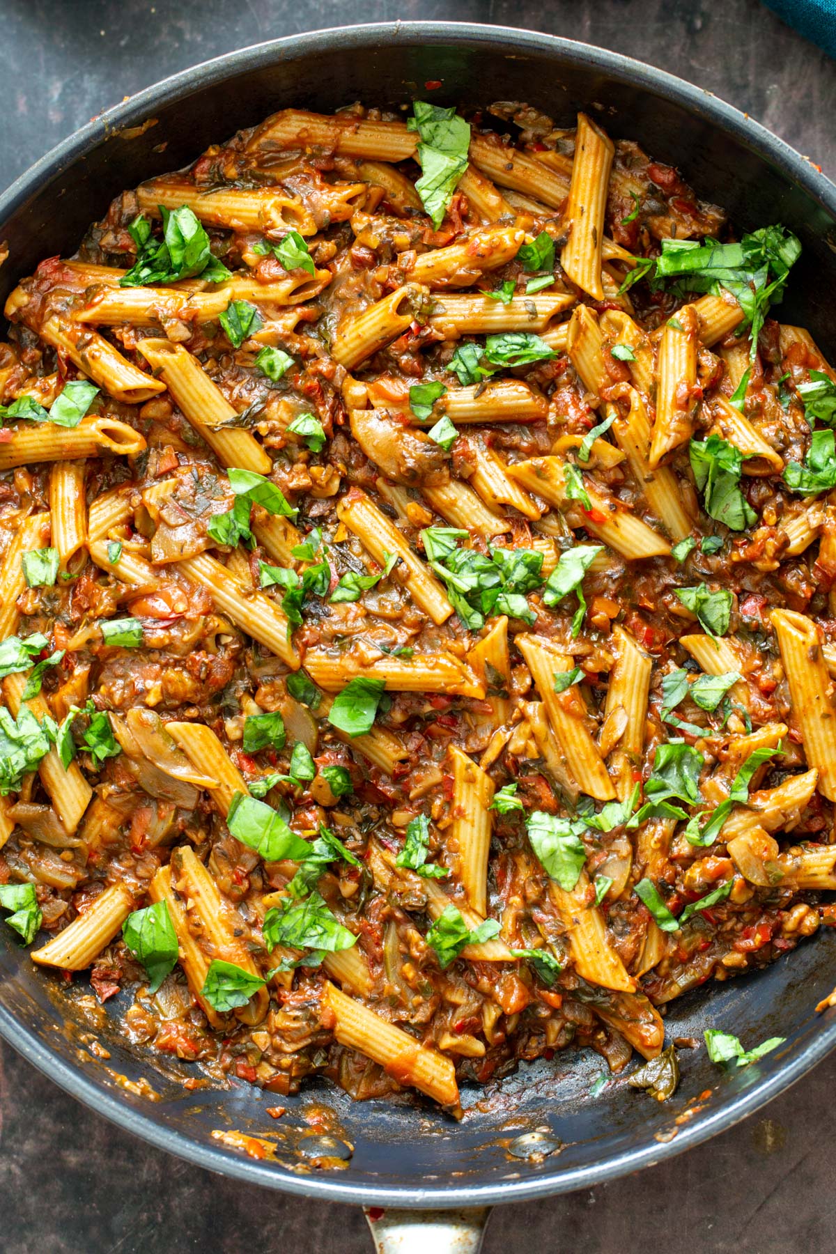 pasta in vegetable sauce in a black sauteeing pan 