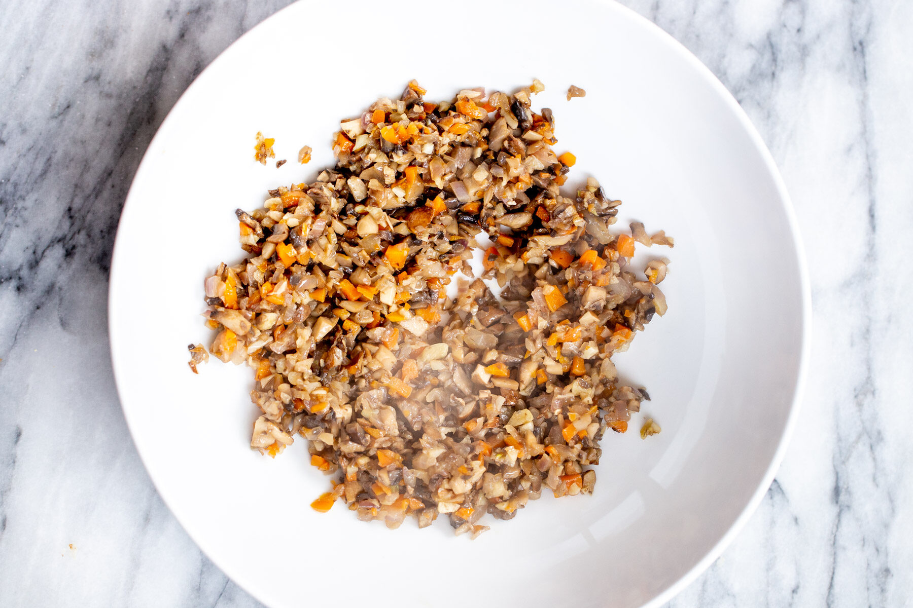 sauteed mushrooms and carrots in a sauteeing pan