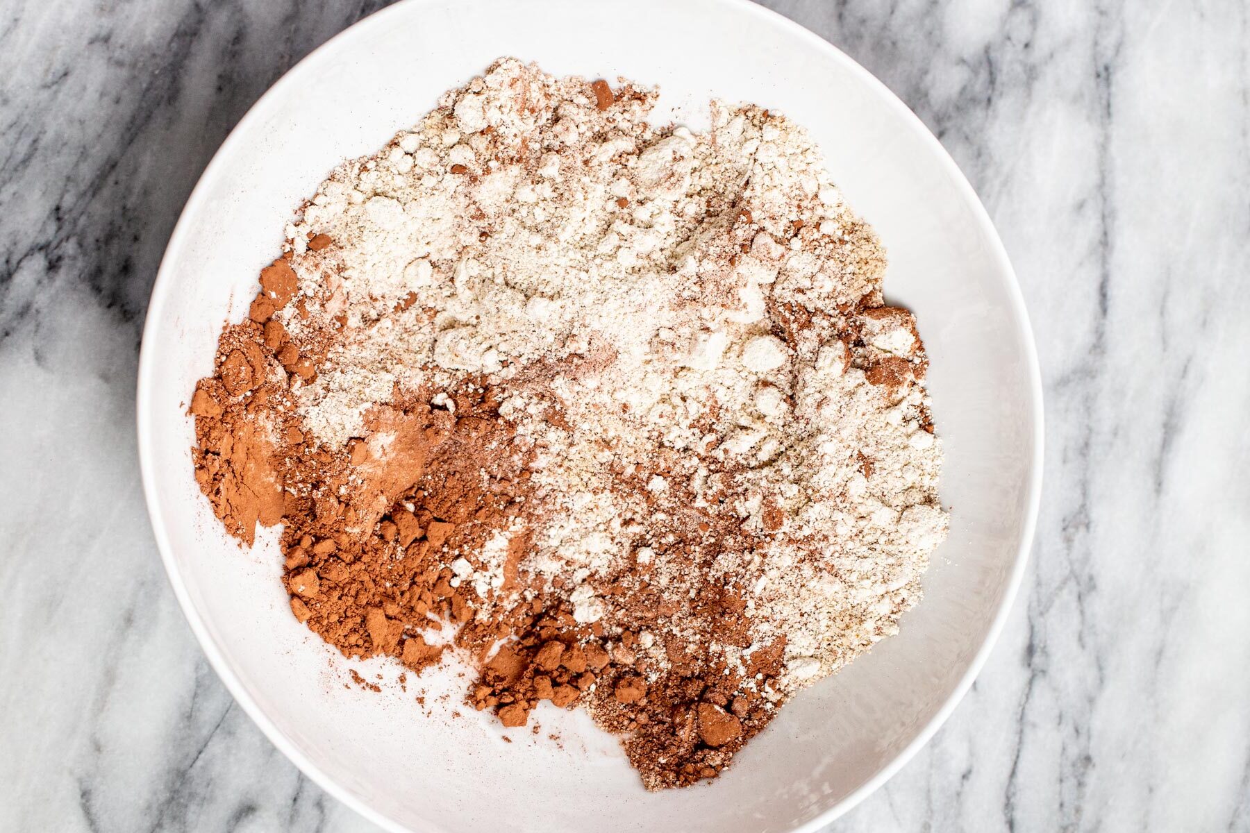 dry ingredients for peanut butter chocolate tart shell in a white bowl