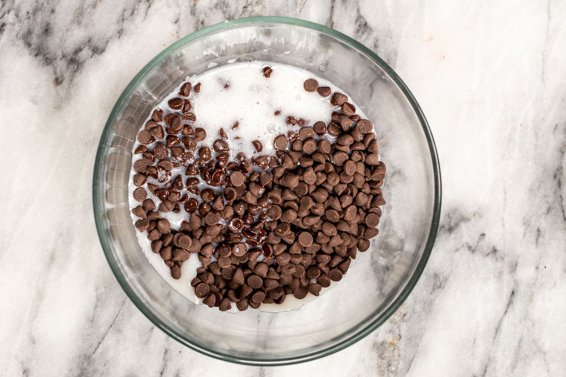 coconut milk and chocolate chips in a glass bowl
