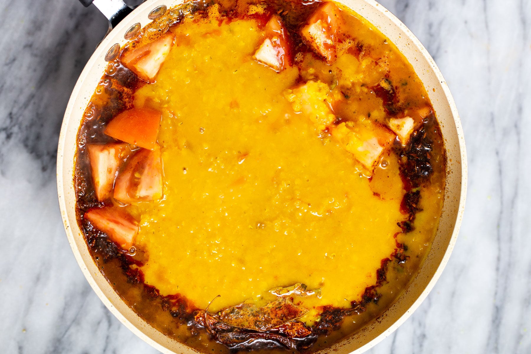 daal being added to a pan with indian tempering
