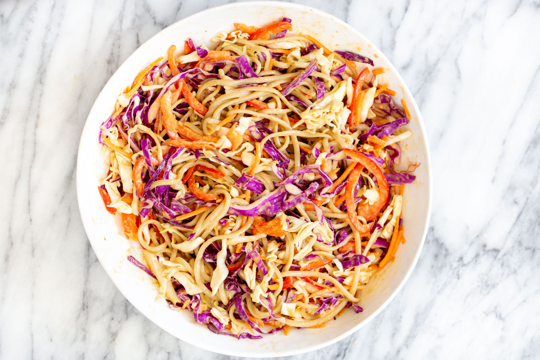 a white bowl with peanut sesame noodle salad