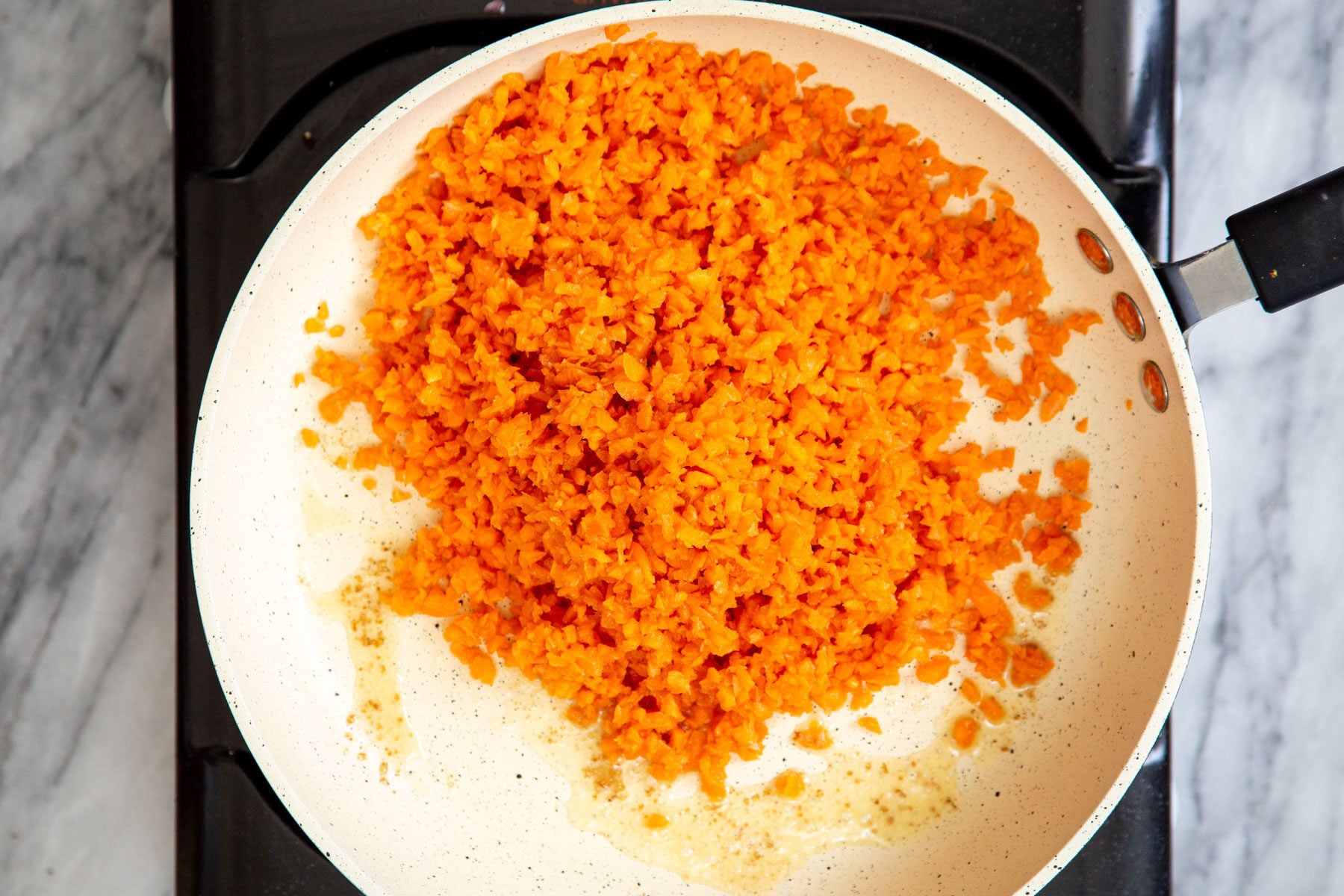 shredded carrots in a sauteeing pan 