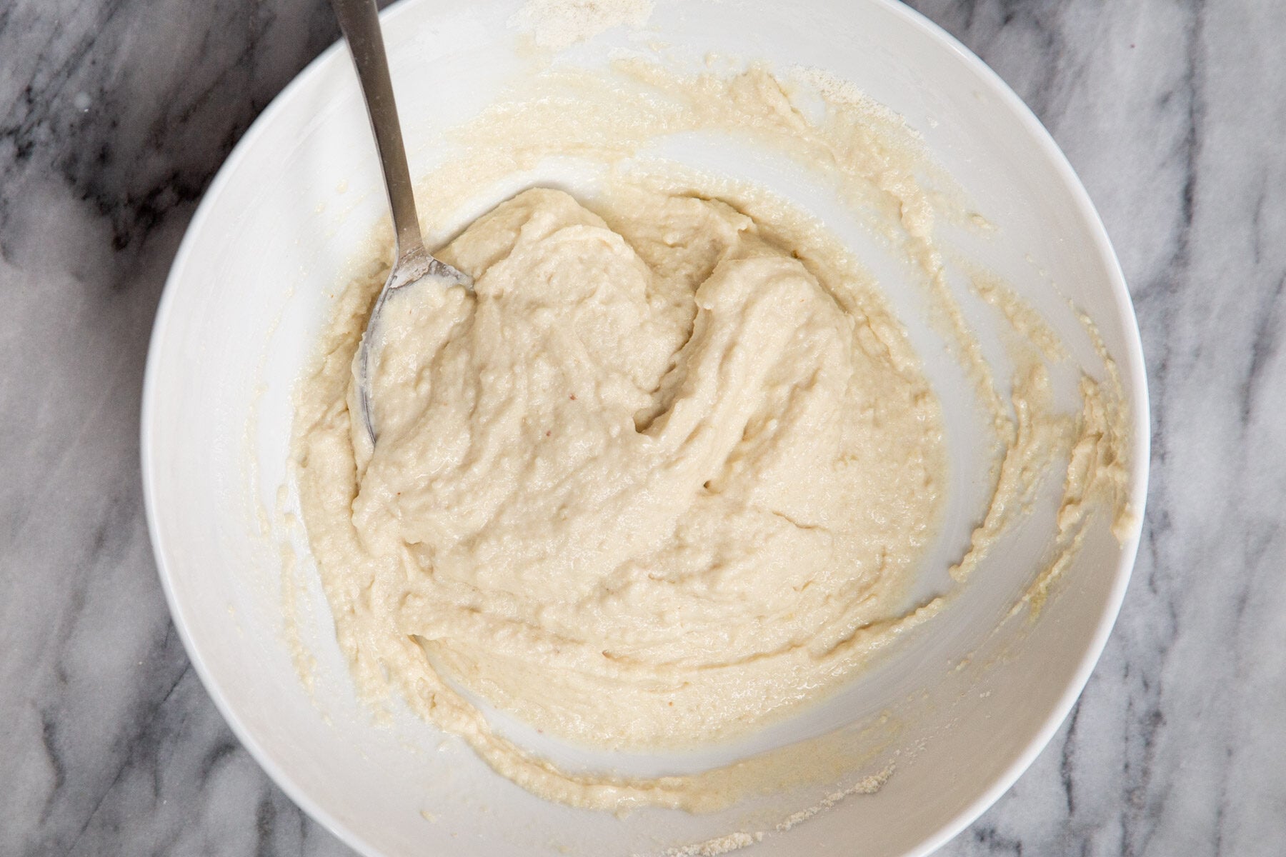 almond flour pizza dough with a spoon in a white bowl