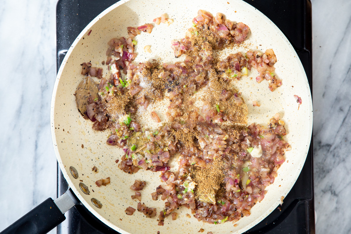 ground spices being added to tempering