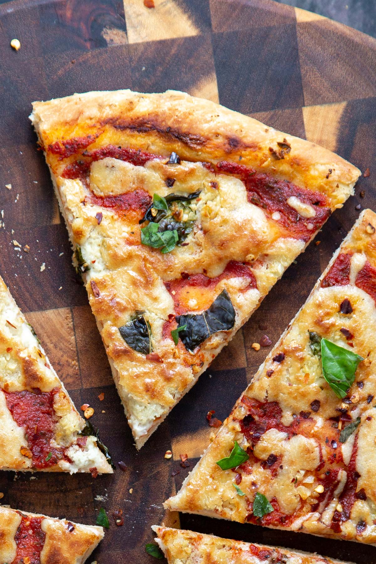 sliced vegan mozzarella pizza on a chopping board 