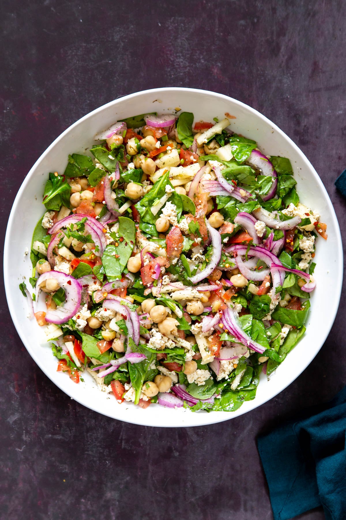 a white bowl with vegan chickpea salad drizzled with lemon dill dressing
