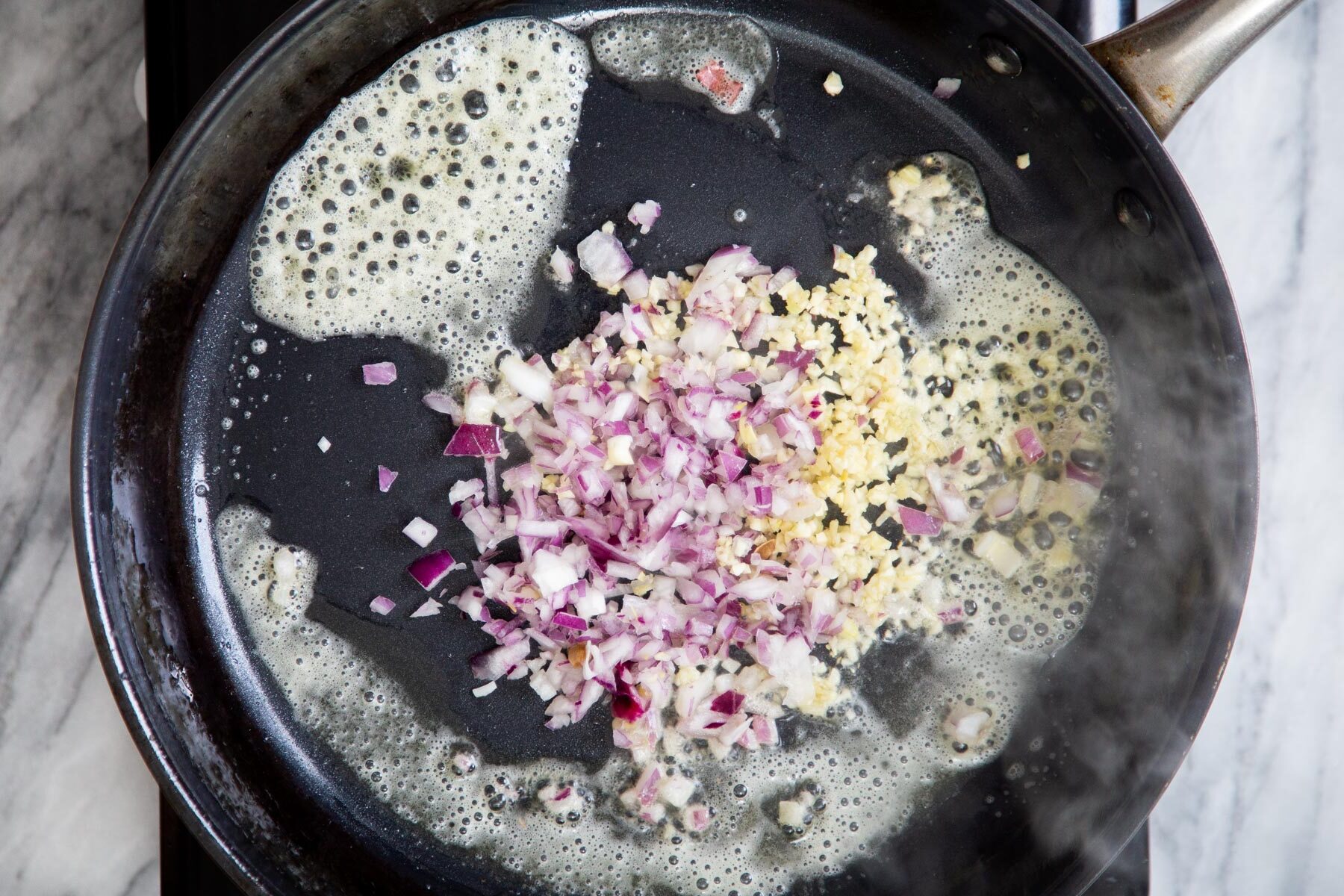 minced almond and garlic being sauteed in vegan butter