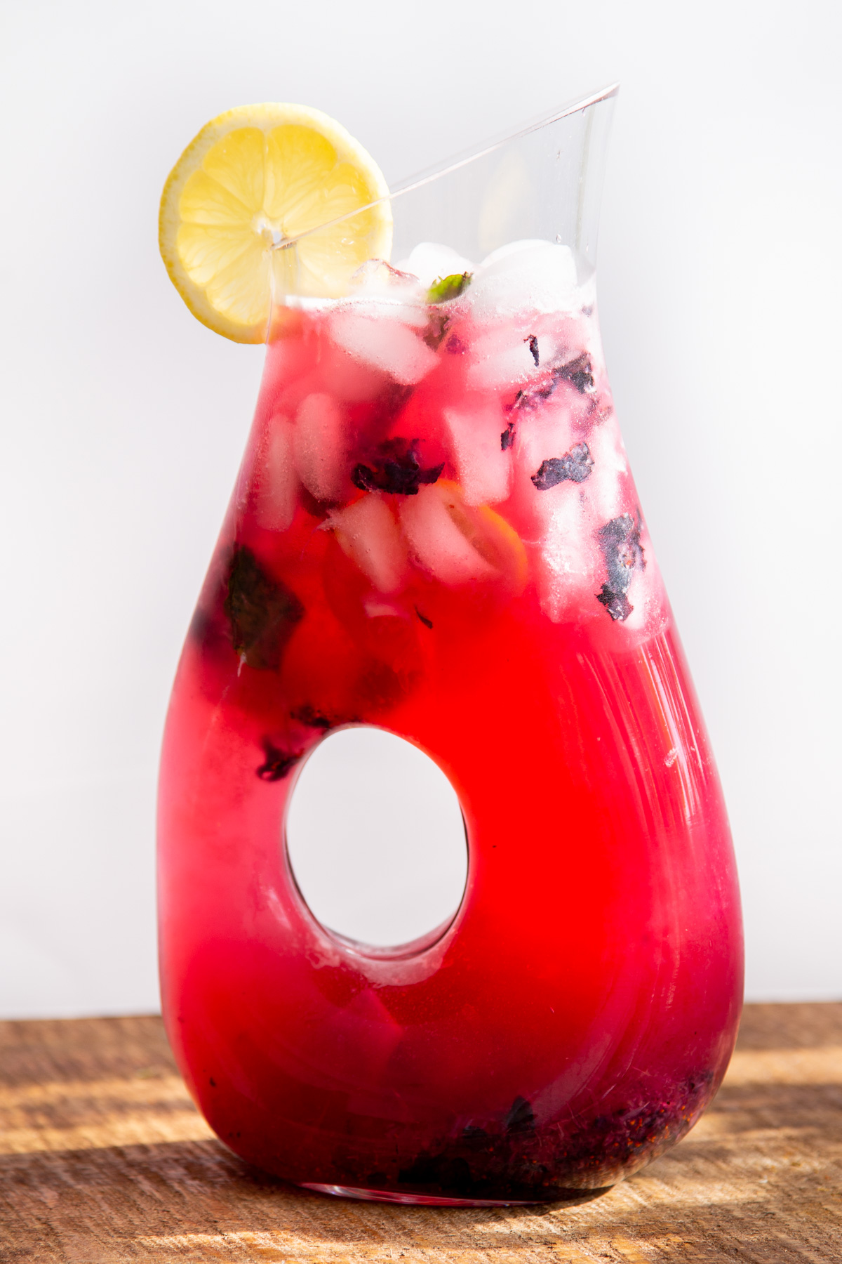 a glass jar of homemade fresh blueberry lemonade with ice cubes and mint leaves