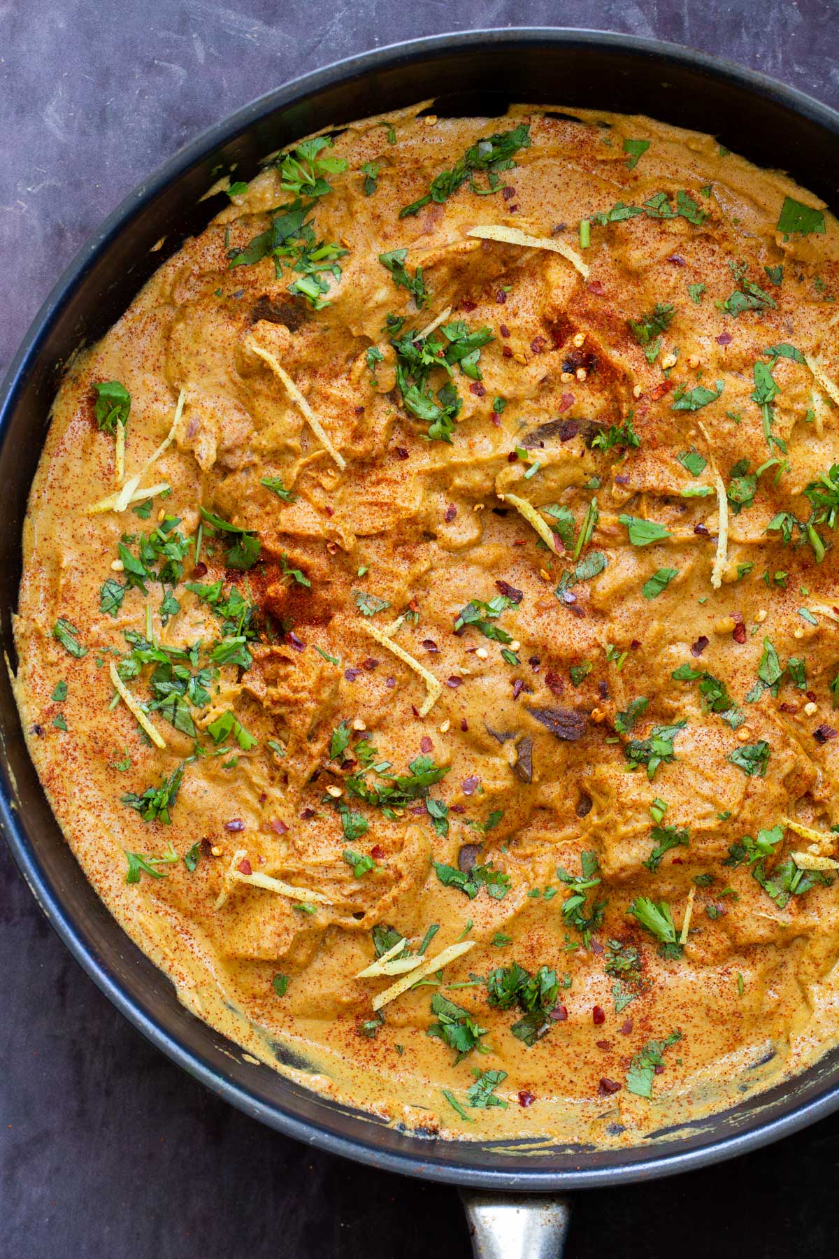 a black skillet with vegan chicken korma with jackfruit