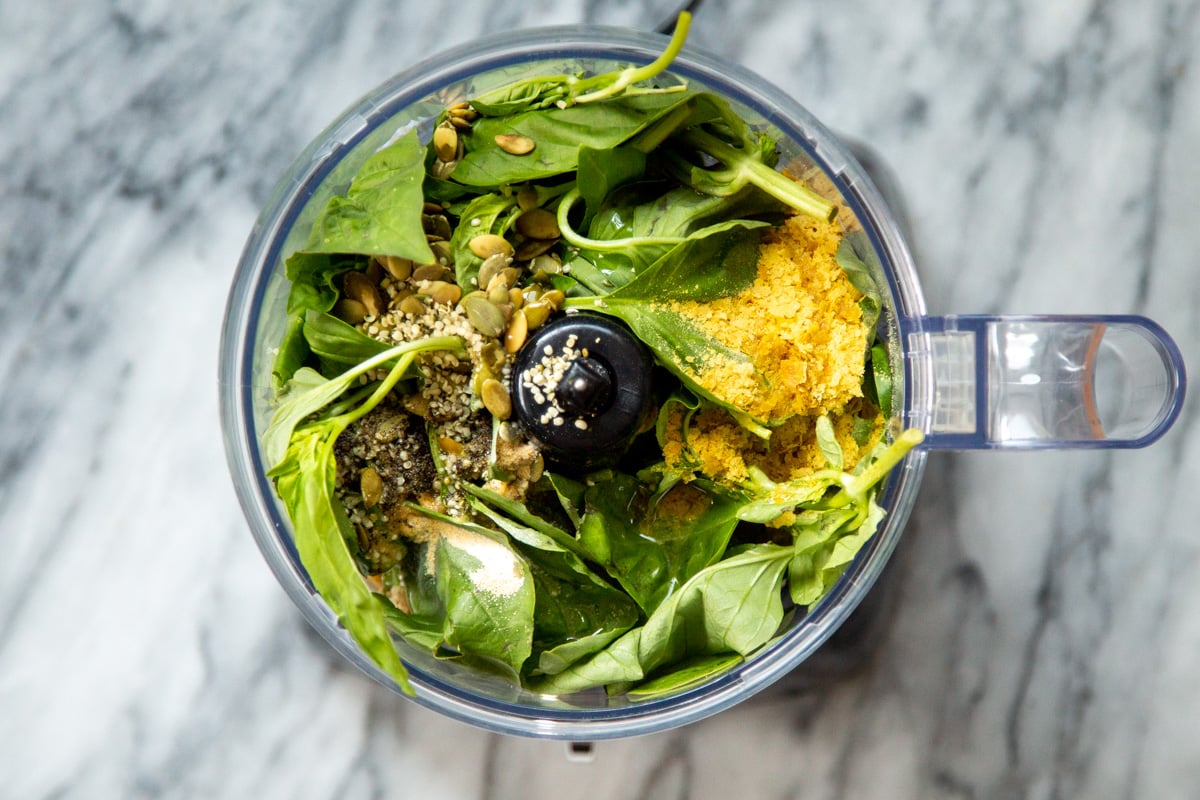 seeds and nutritional yeast being added to food processor