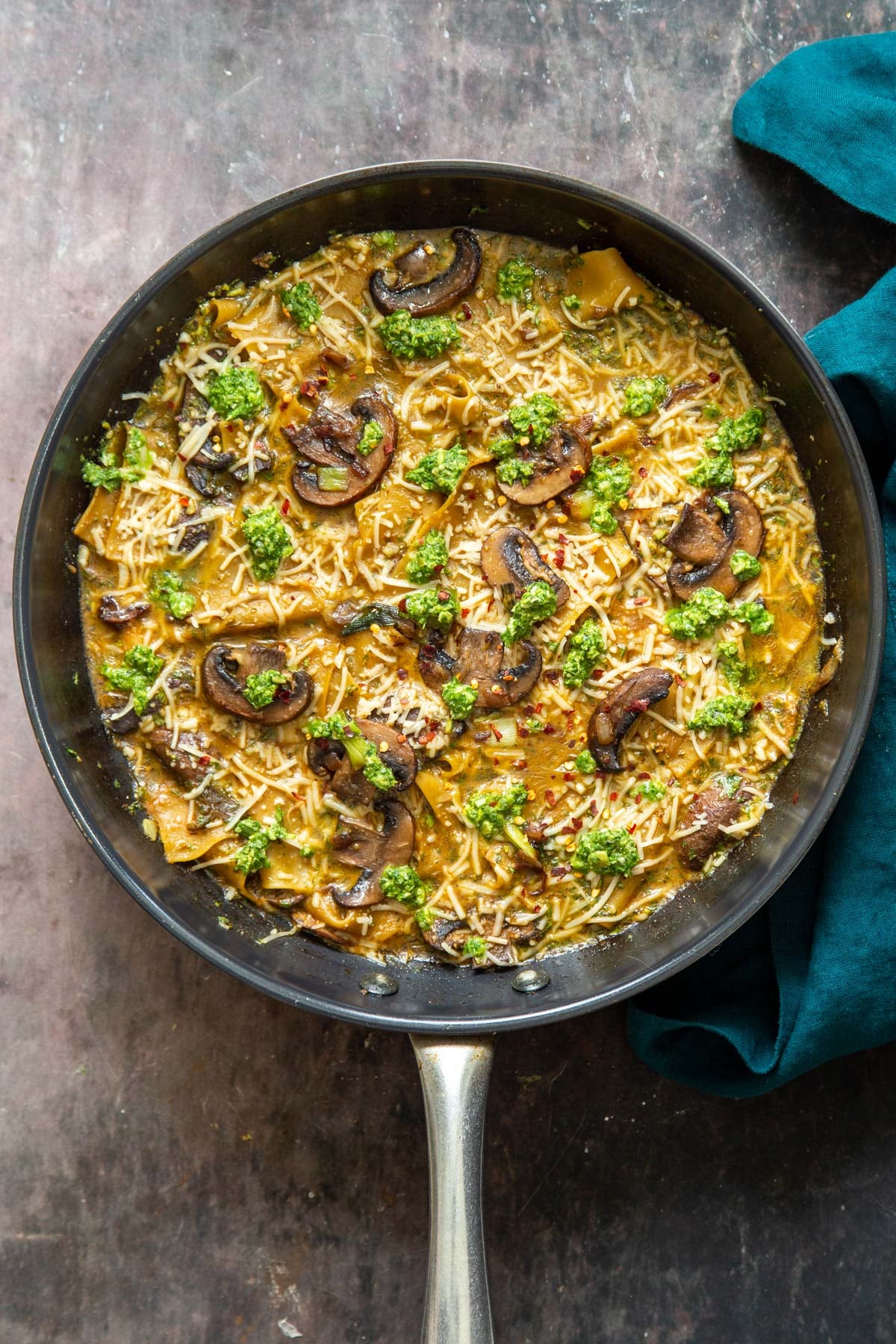 overhead shot of a black skillet with vegan one pan mushroom and pesto lasagna