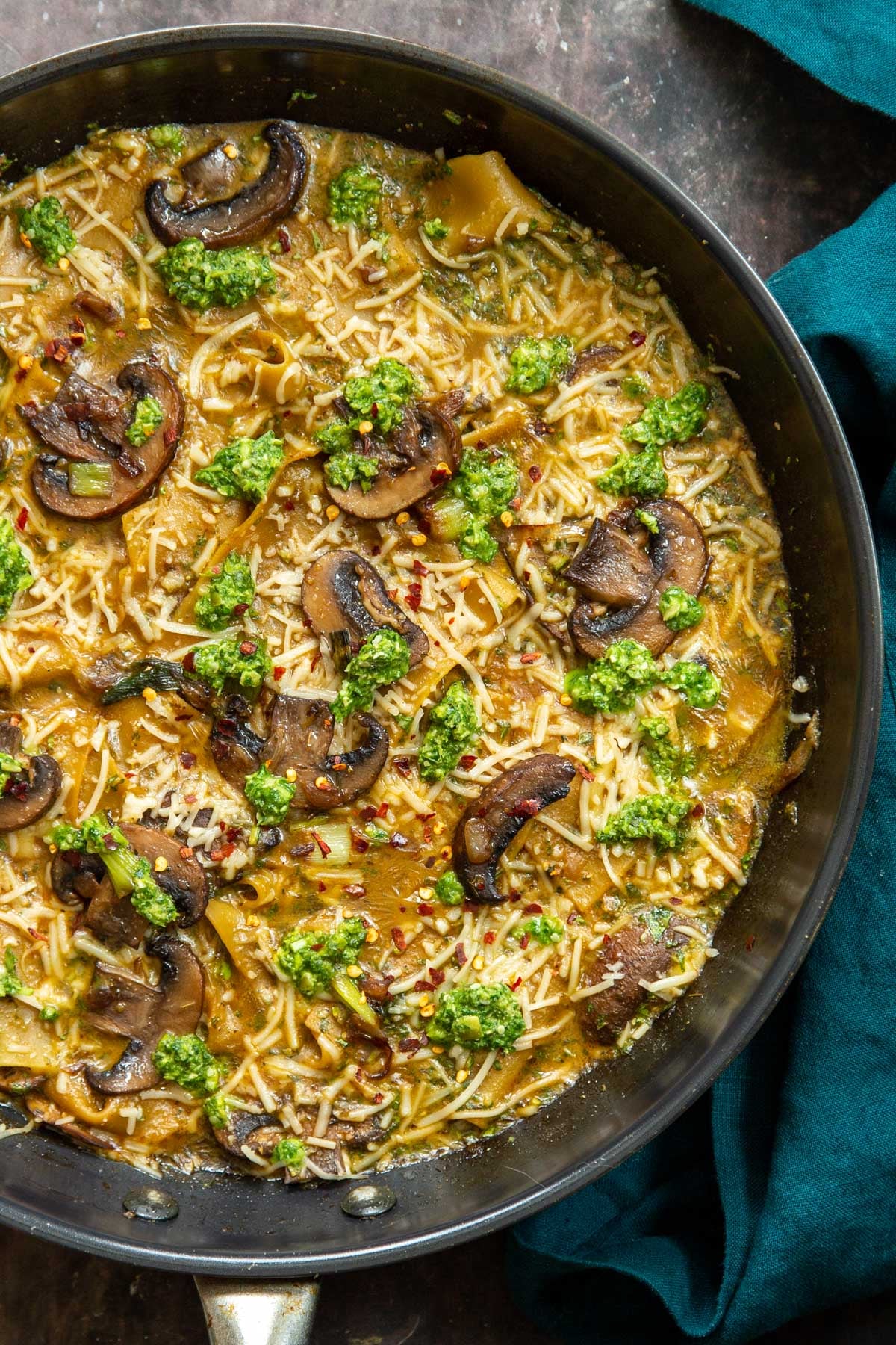 overhead shot of a black skillet with vegan one pan mushroom and pesto lasagna