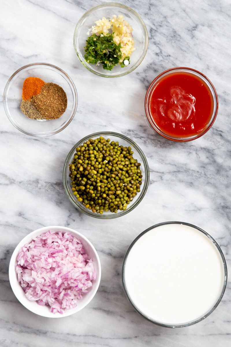 ingredients needed for making sabut moong dal on a marble countertop 