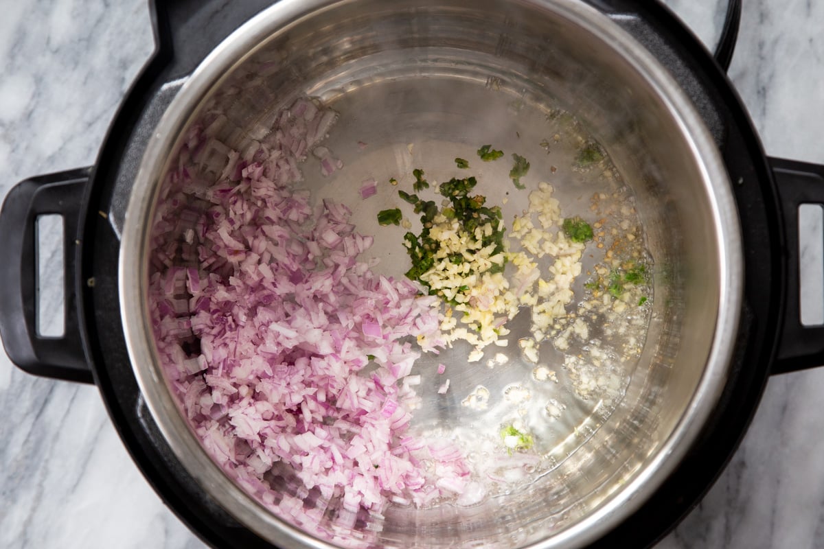 chopped red onions, chili and garlic in an Instant Pot 