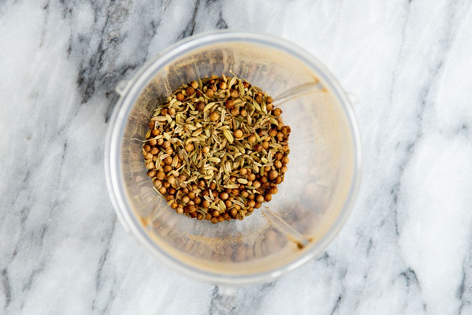 fennel seeds and coriander in a grinder