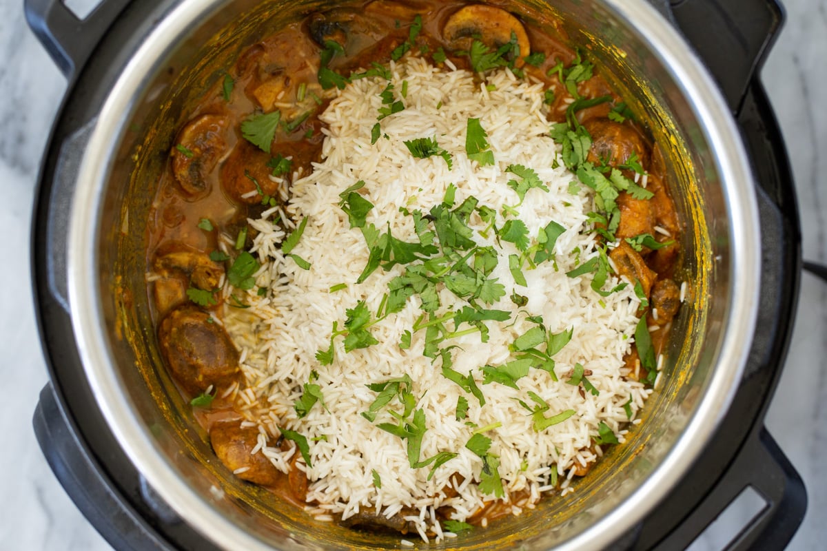 mushrooms in Indian gravy and drained soaked rice with chopped cilantro leaves