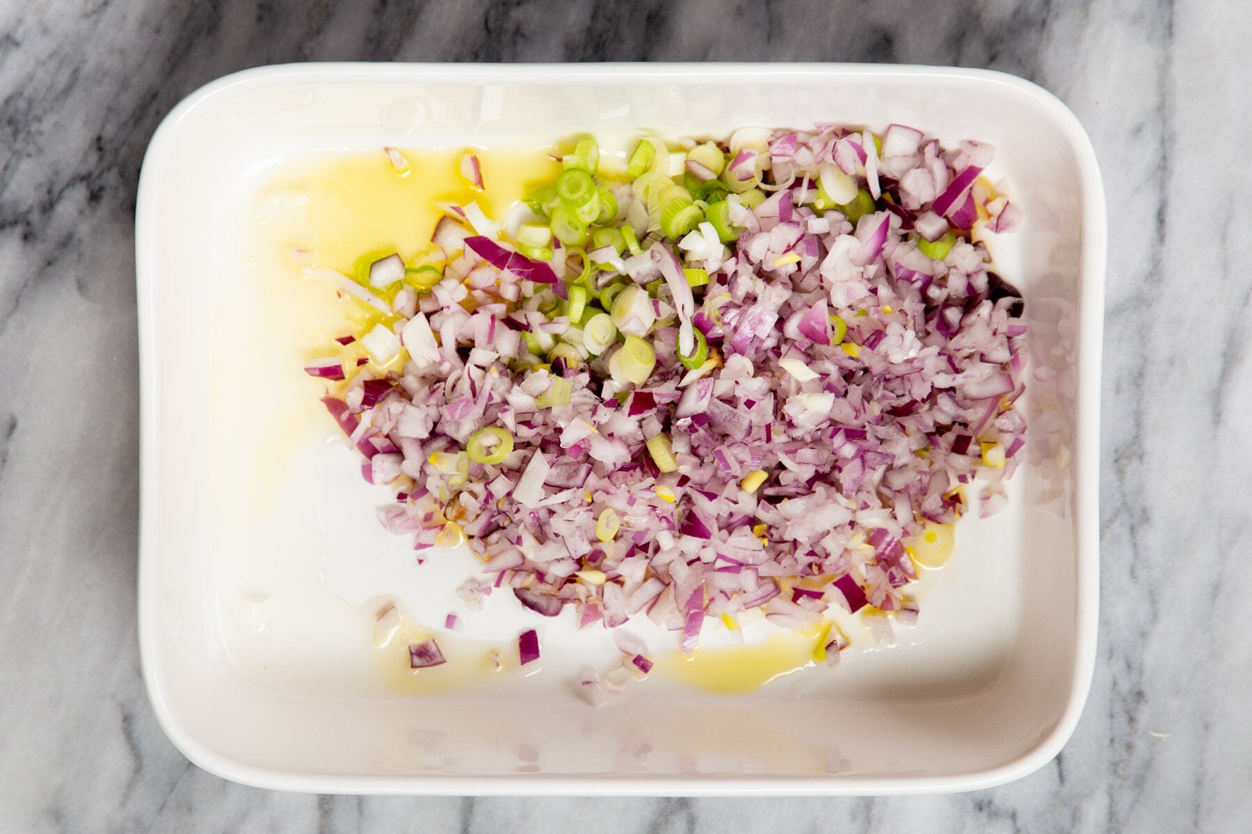 minced onion, green onion and ginger in a casserole dish